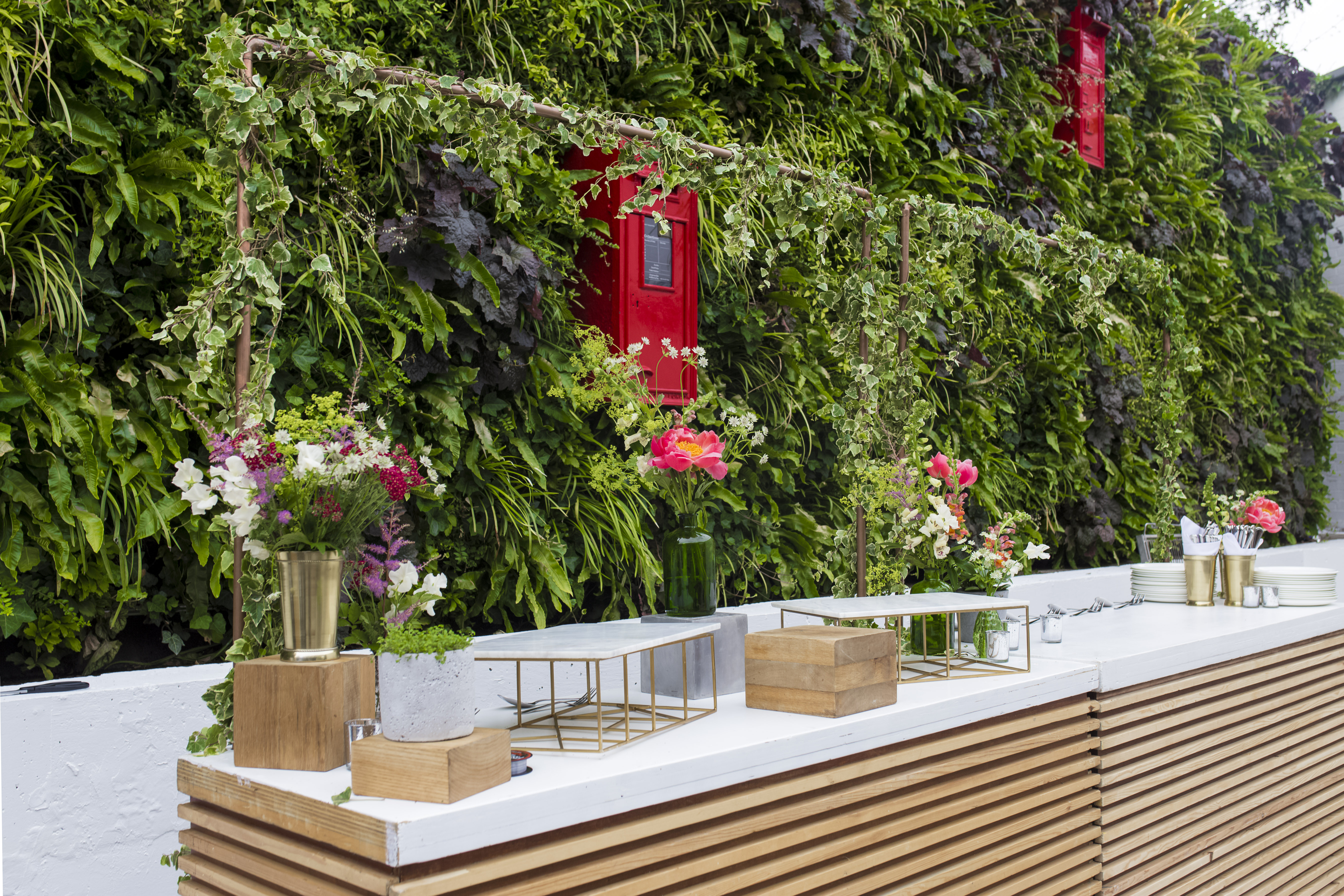 Elegant event space at The Postal Museum with lush green wall, perfect for receptions.