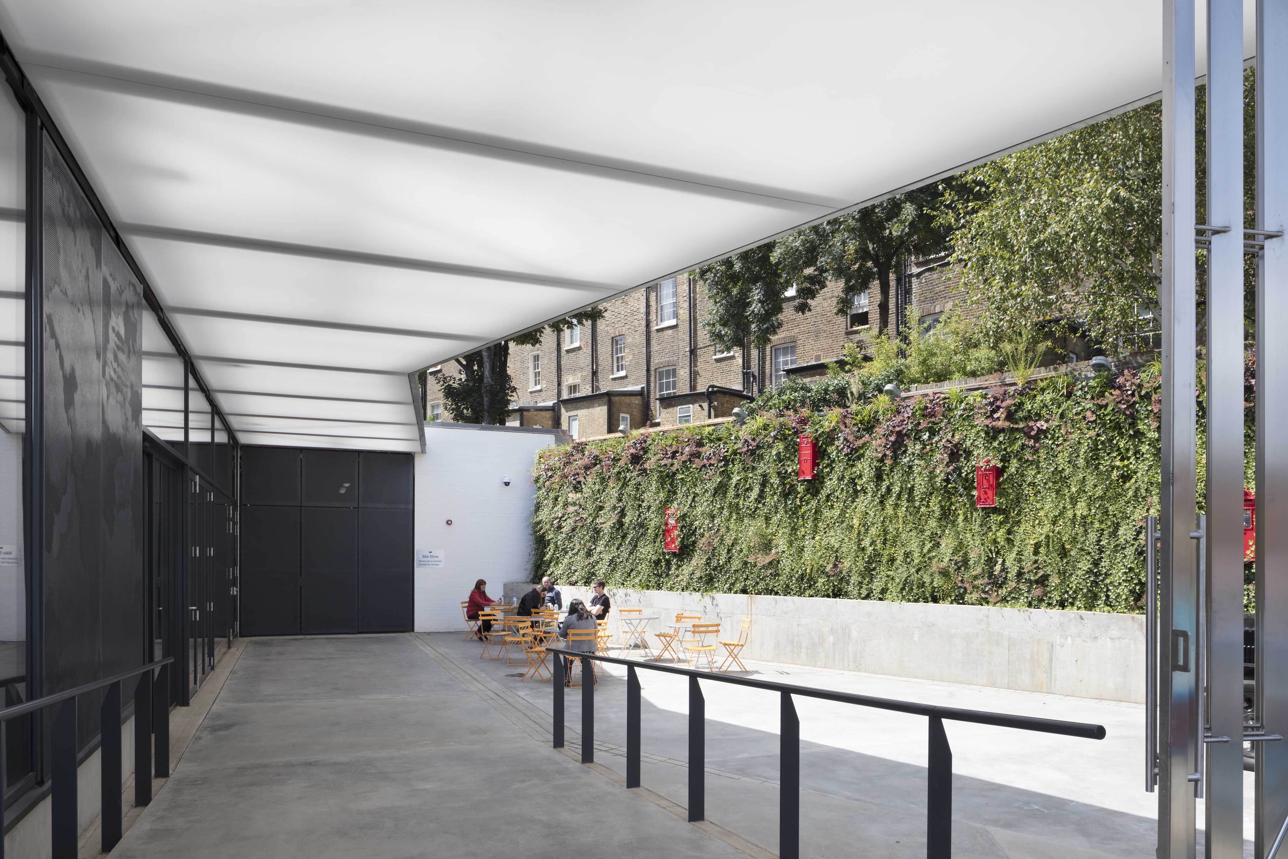 Modern event space with greenery at The Postal Museum's Courtyard. Ideal for gatherings.
