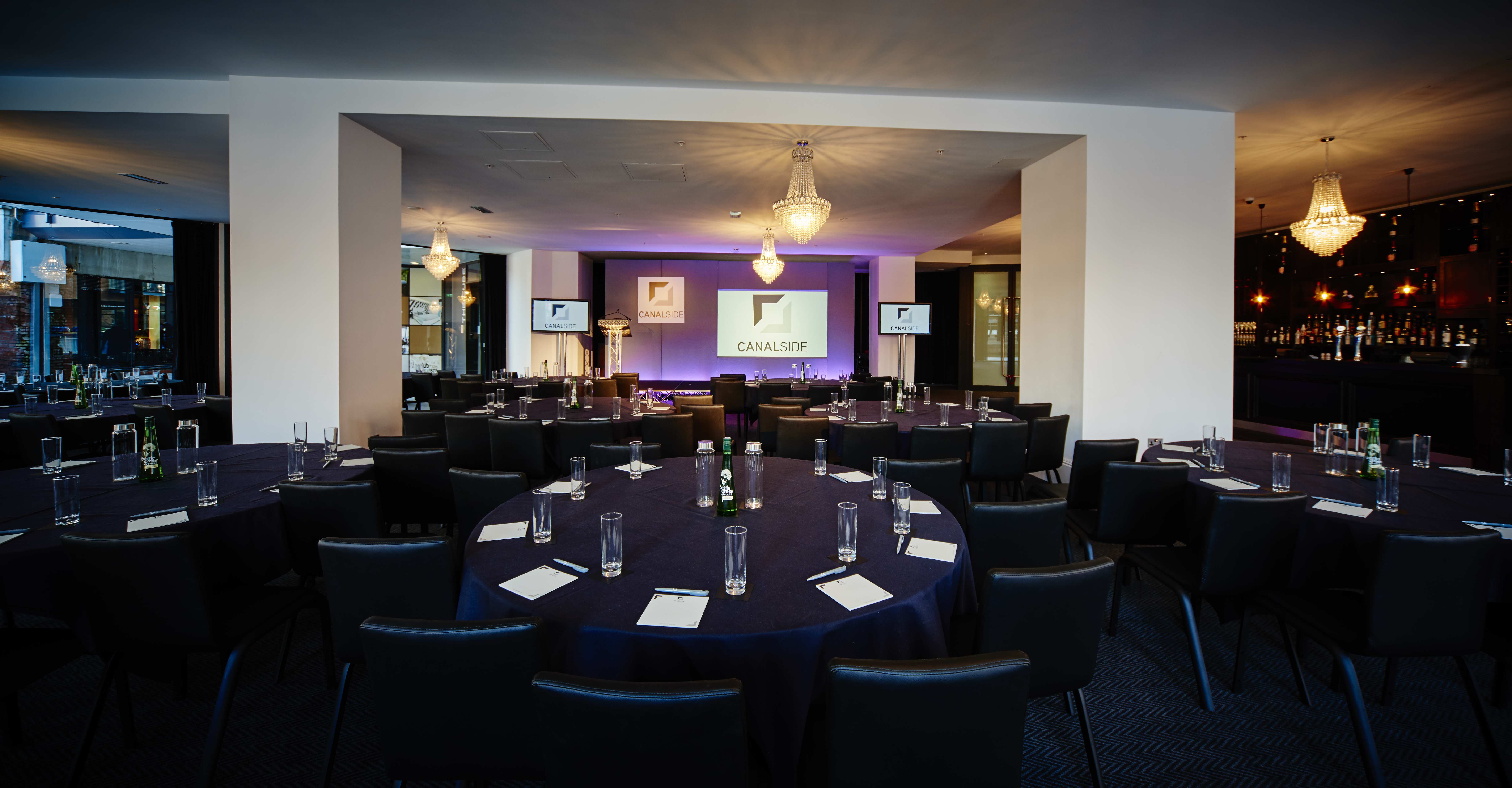 Elegant meeting space at Canalside with round tables for corporate events.