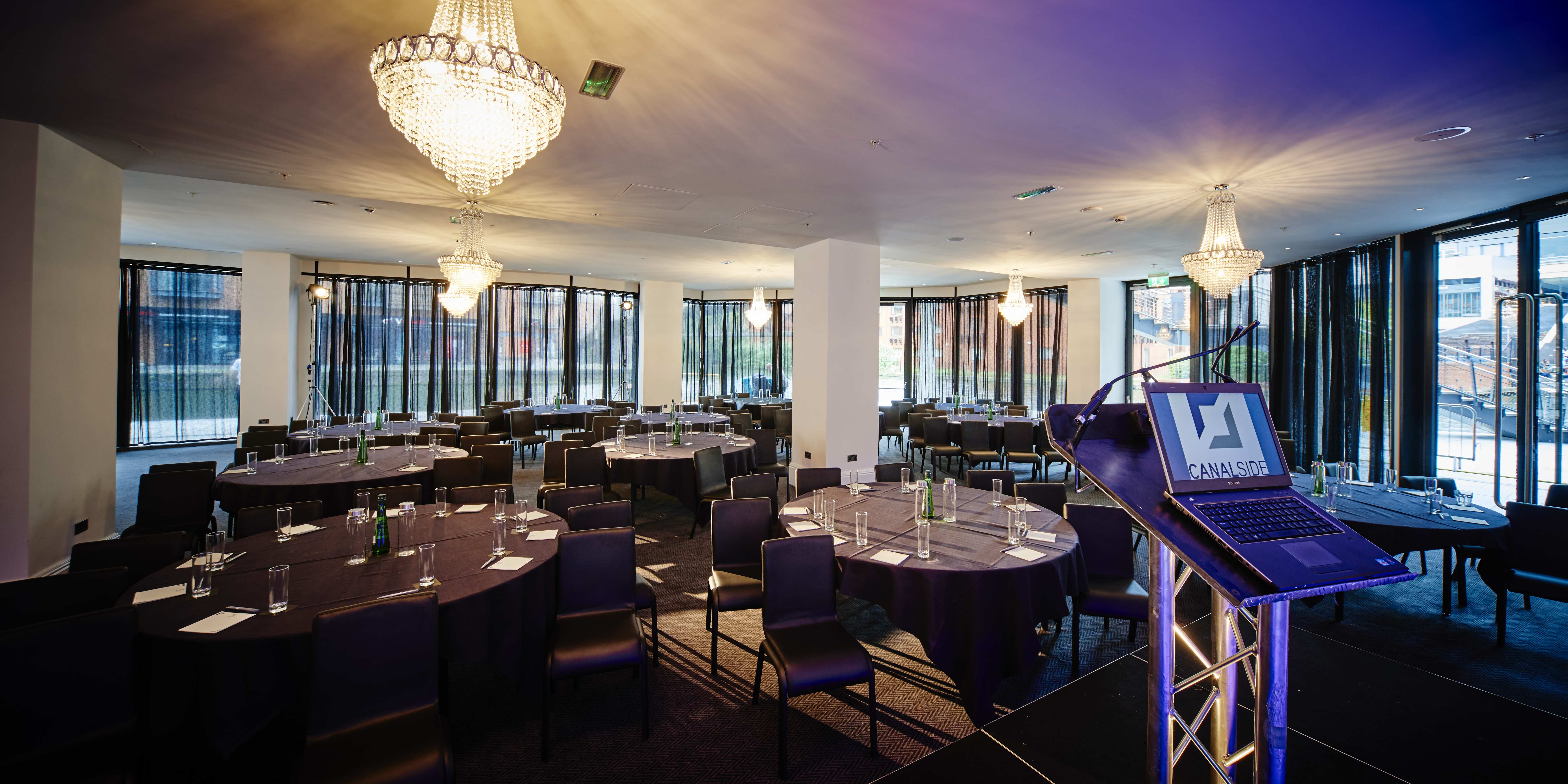 Sophisticated conference venue with round tables and natural light at Canalside.