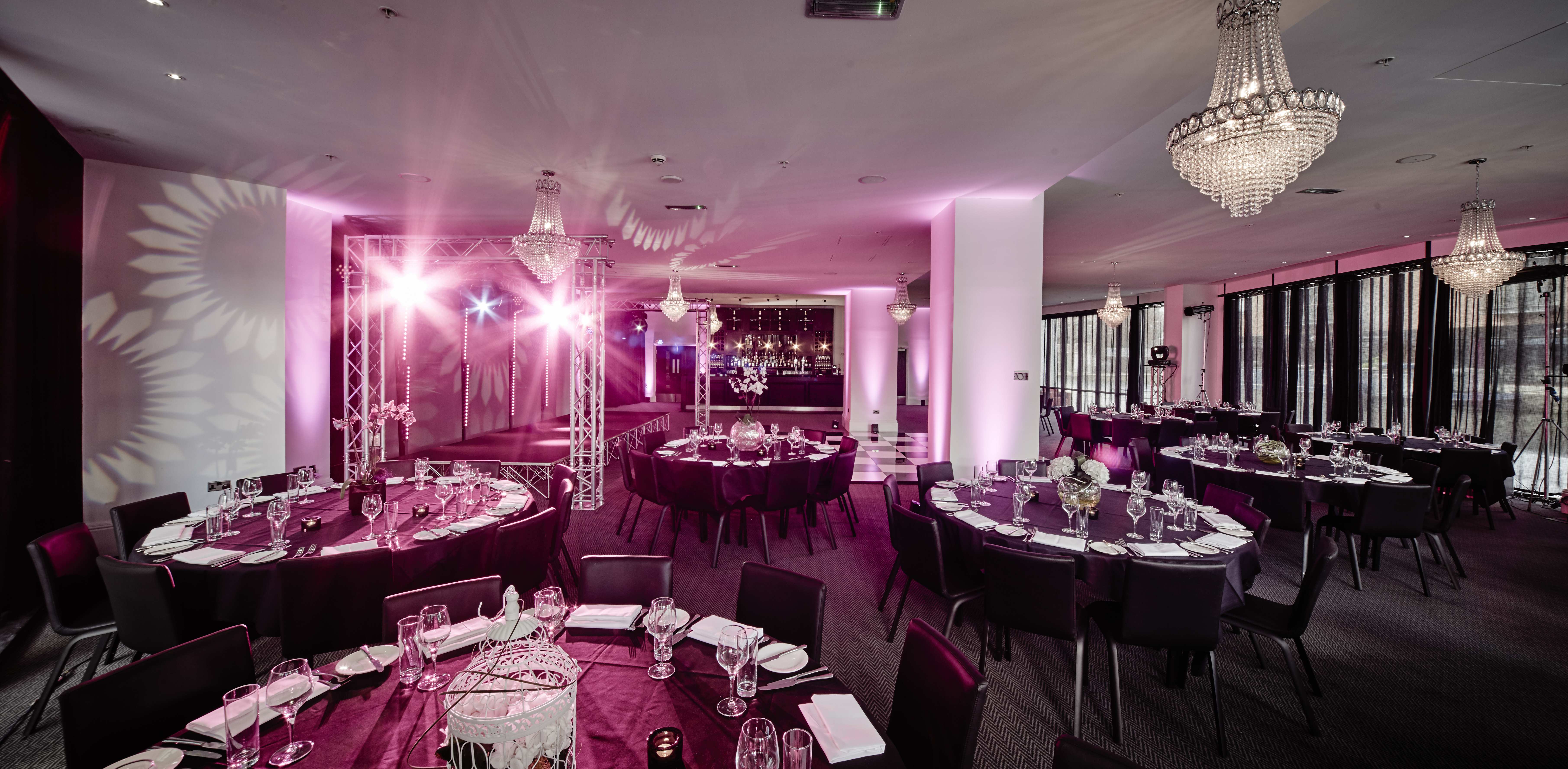 Elegant Canalside venue set for a gala dinner with ambient lighting and round tables.