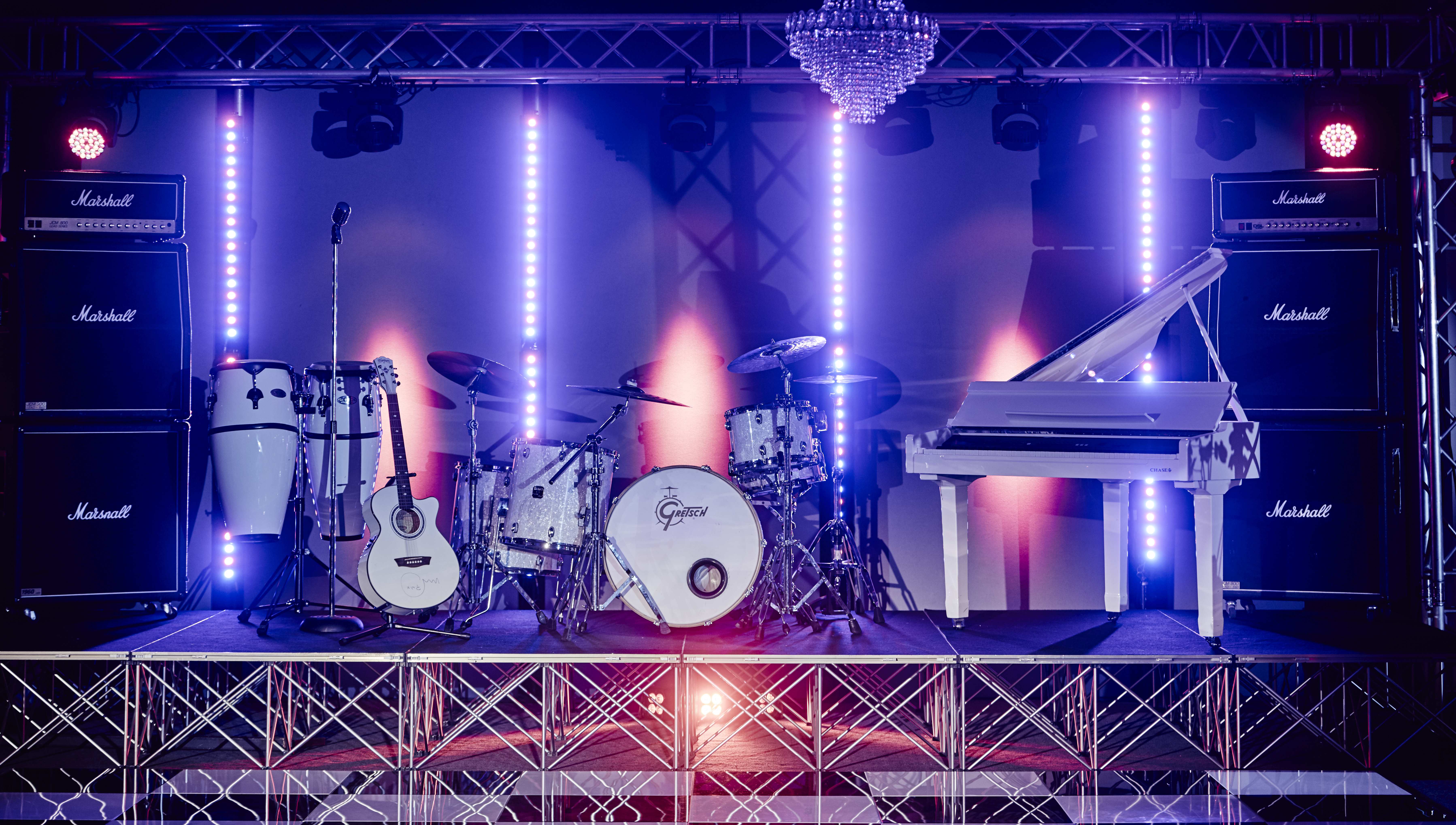 Vibrant stage with grand piano and drum kit at Canalside for live concerts and events.