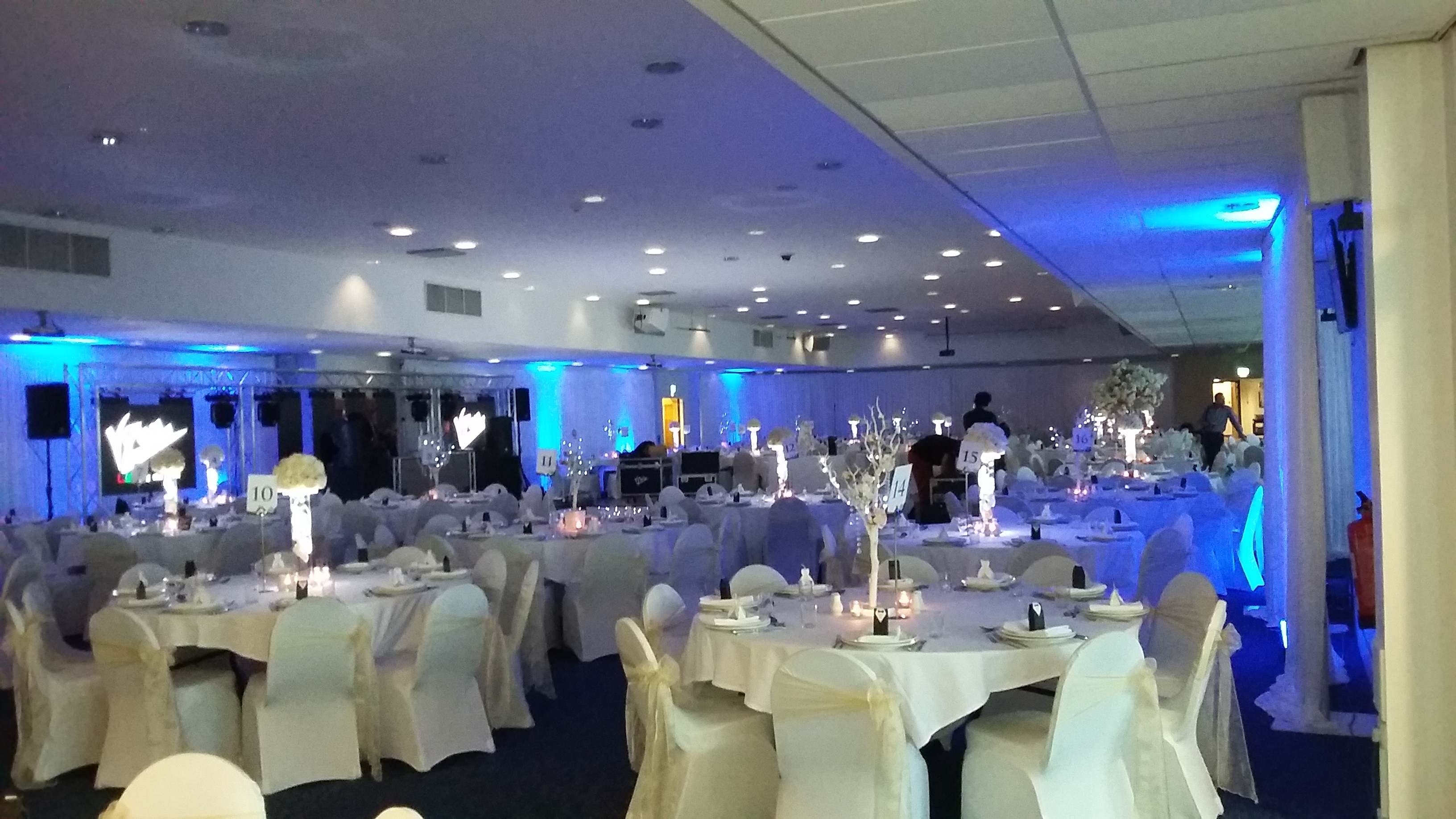 Elegant event space at Leicester City FC with round tables and soft blue lighting.