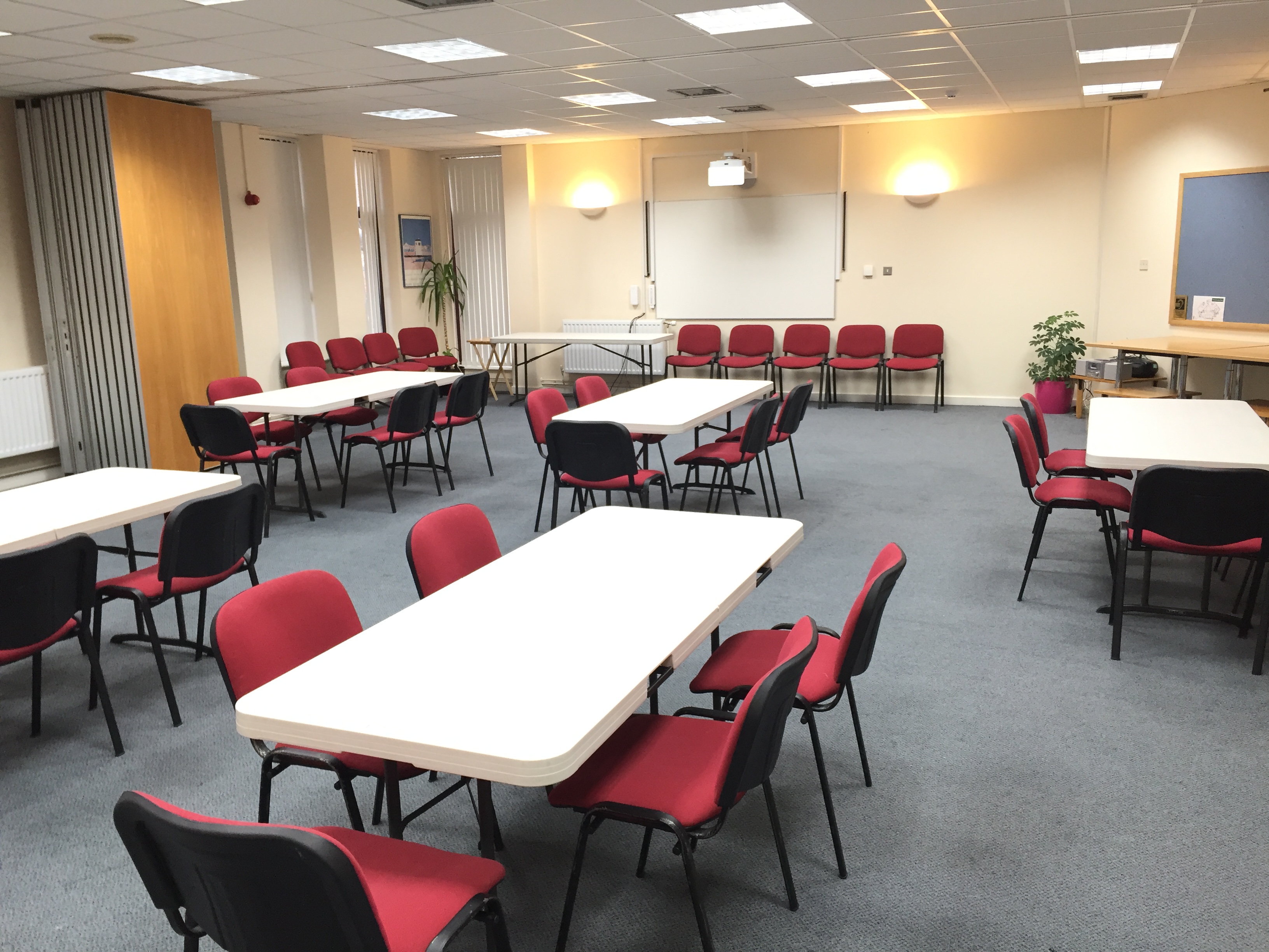 Versatile seminar space with natural light, ideal for workshops and conferences.