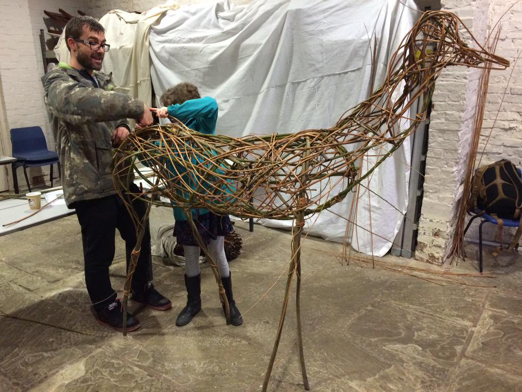 Creative workshop at Blakesley Hall barn with participants crafting a willow sculpture.