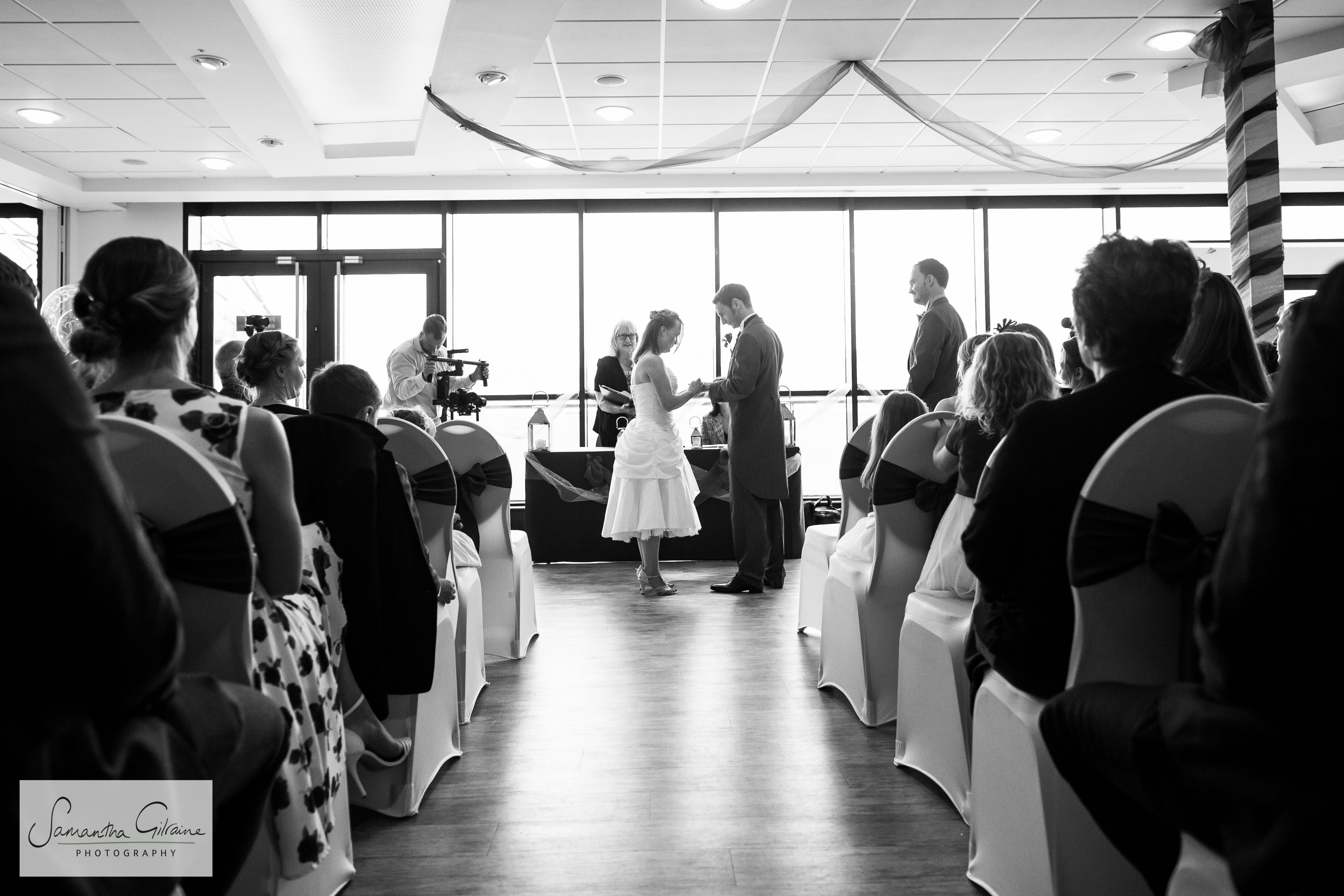 Elegant wedding ceremony setup in M Shed with natural light and beautiful decor.