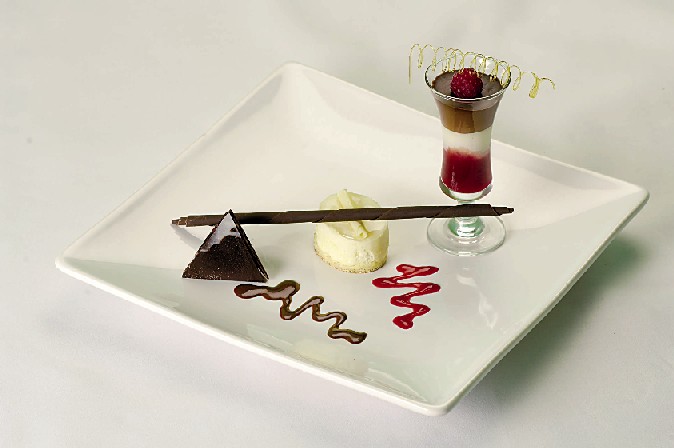 Elegant dessert plate with chocolate pyramid, perfect for gala dinners and upscale events.