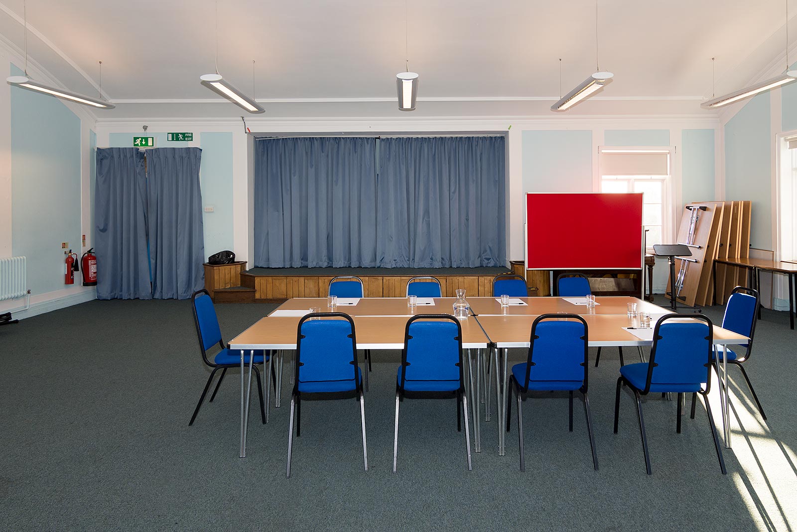 Dulwich Library Hall with central table and blue chairs, perfect for workshops and meetings.