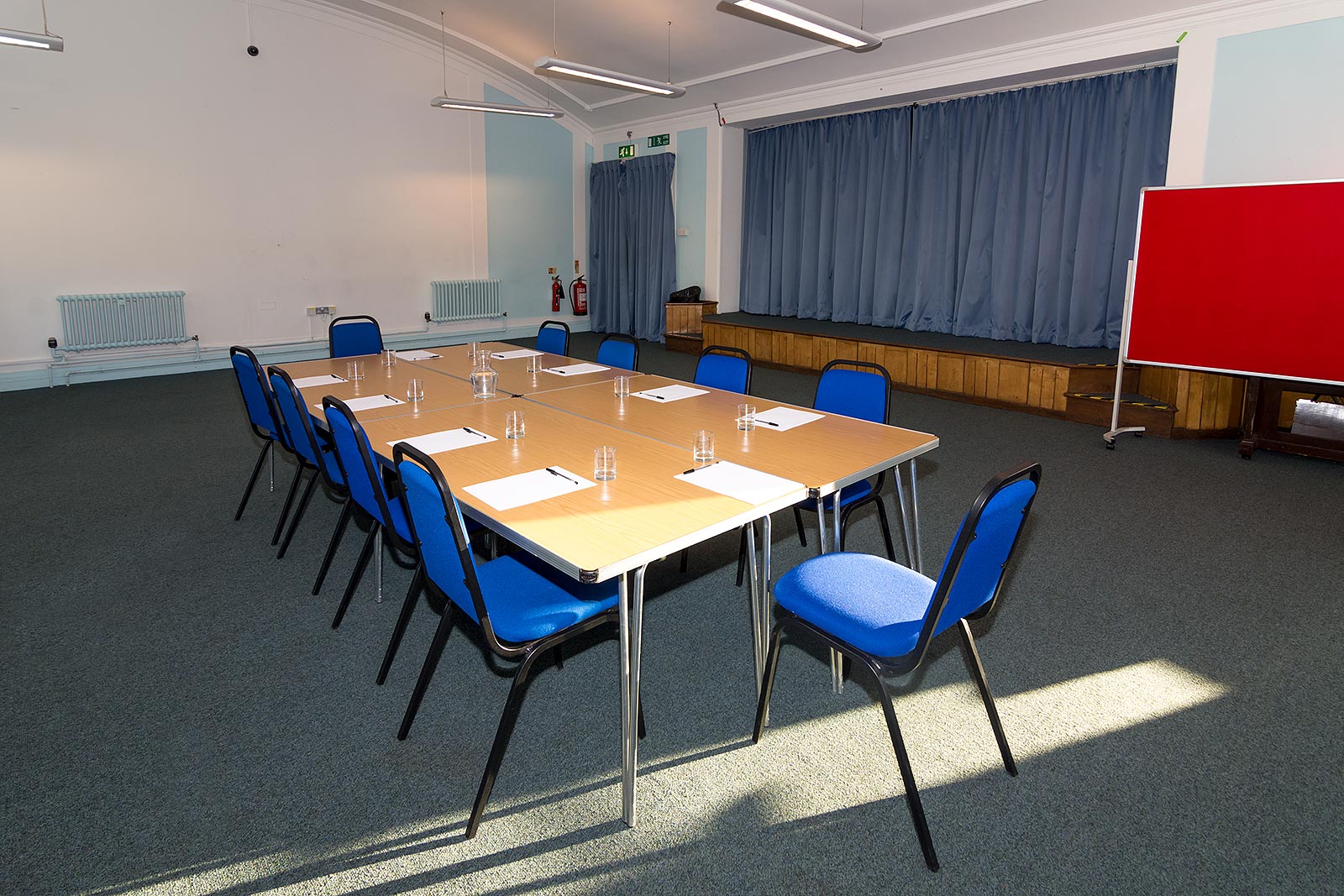 Dulwich Library Hall meeting room with long table, blue chairs for conferences and workshops.