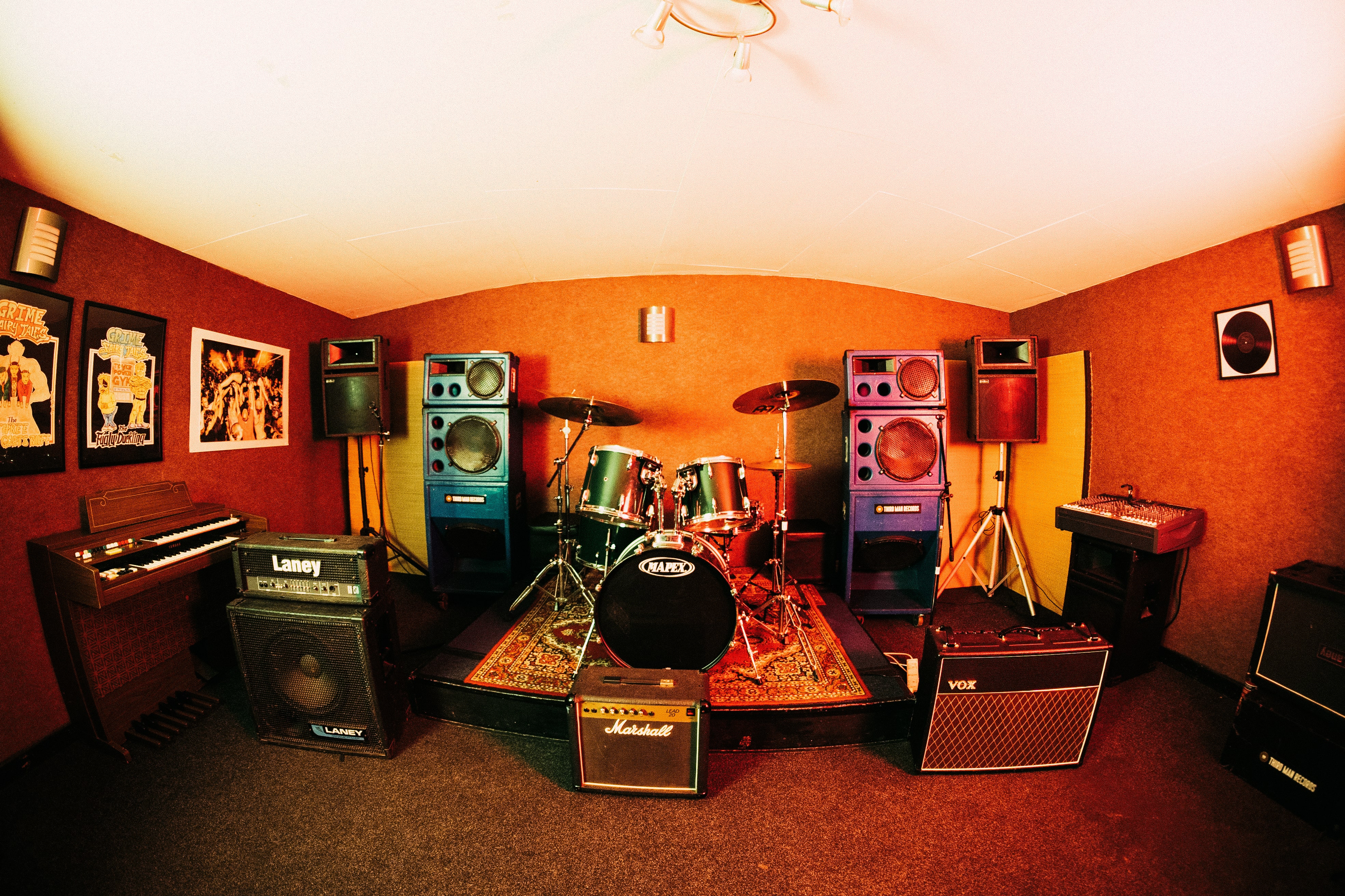 Vibrant rehearsal room with drum kit, ideal for live music events and band practice.