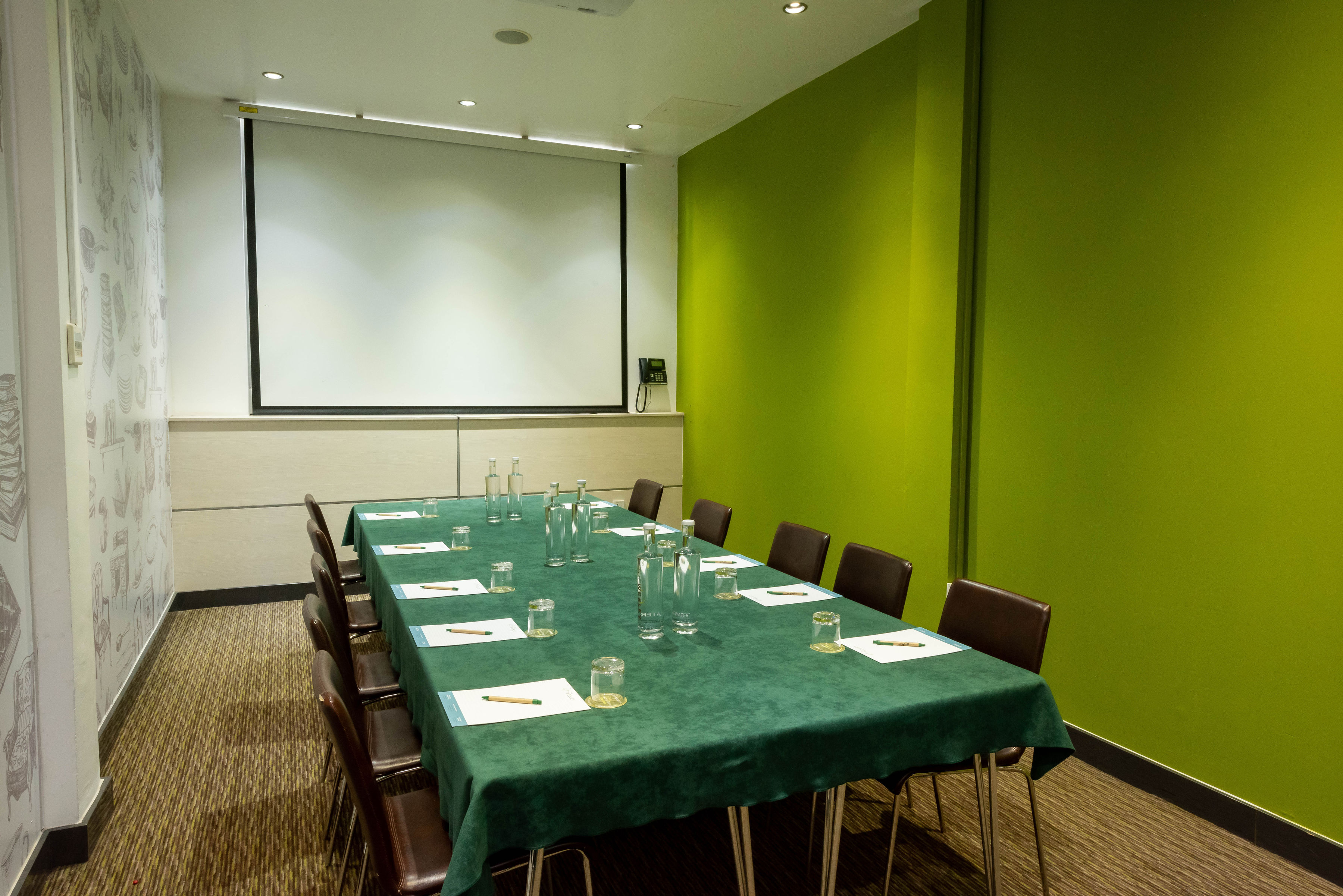 Meeting room in The Wesley Euston Hotel with long table, ideal for workshops and presentations.