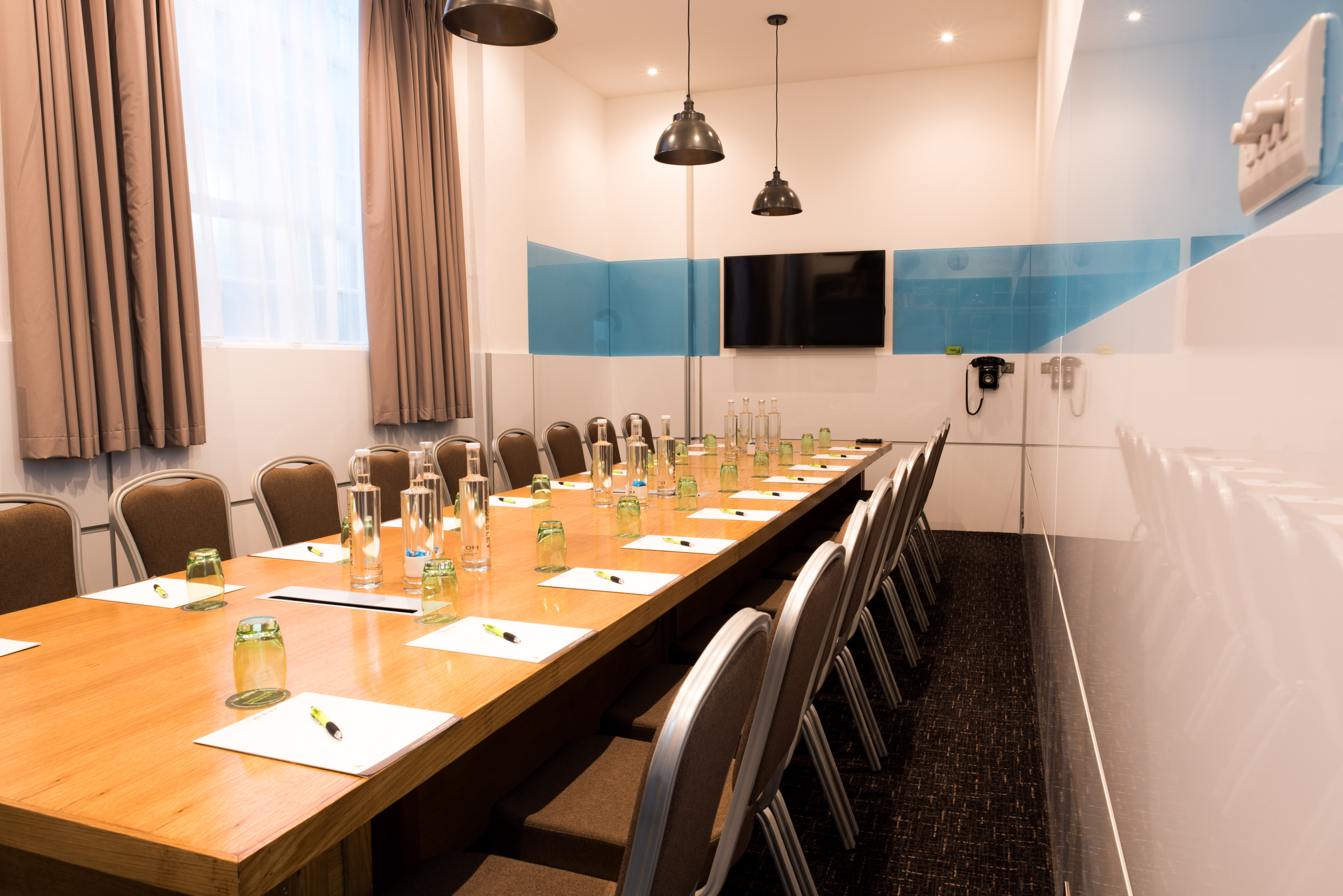 Meeting room at Wesley Euston Hotel, featuring a long wooden table for conferences.