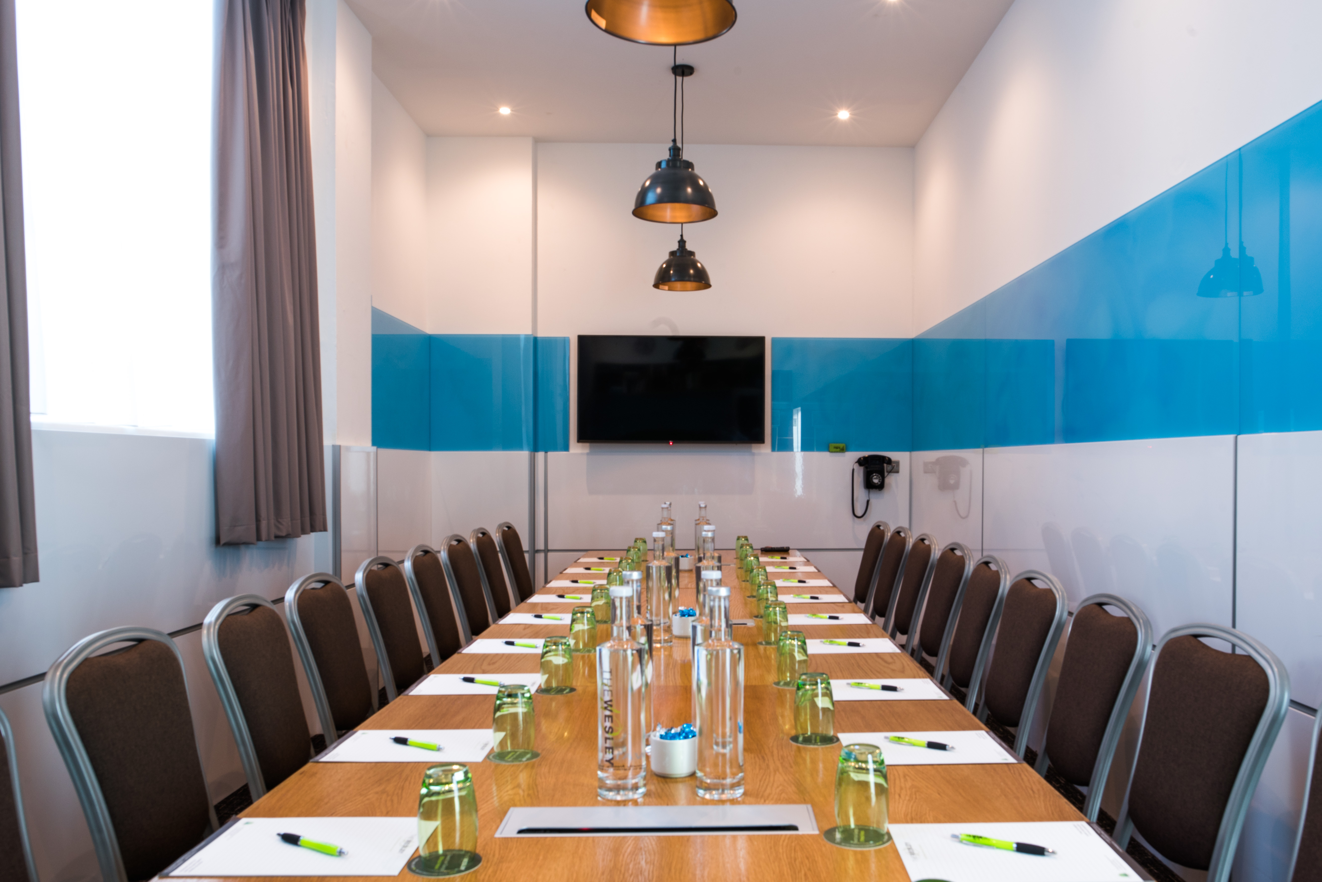 Modern meeting room at Wesley Euston Hotel with long table, ideal for conferences and events.