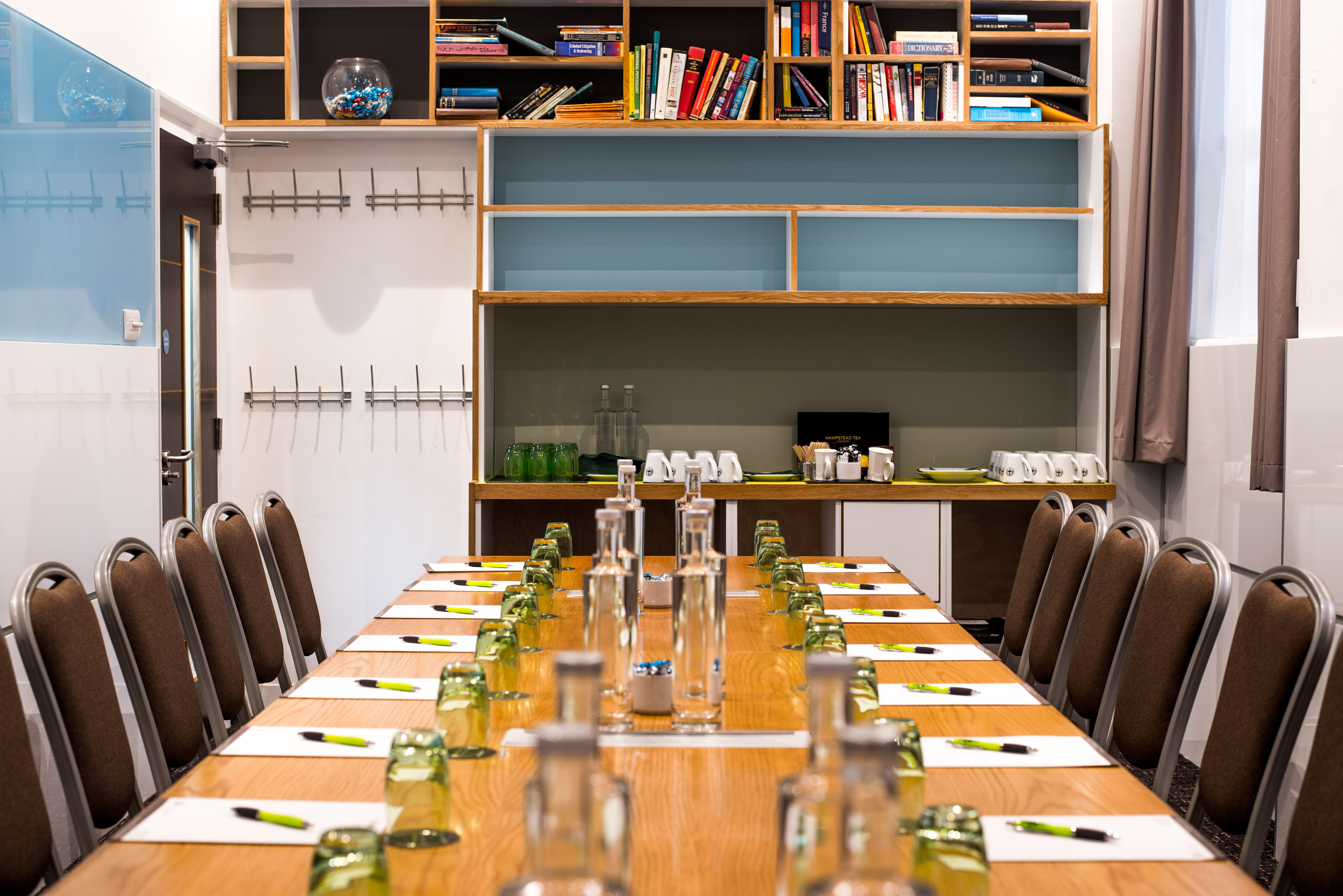 Meeting room with wooden table, water bottles, ideal for workshops and strategy sessions.