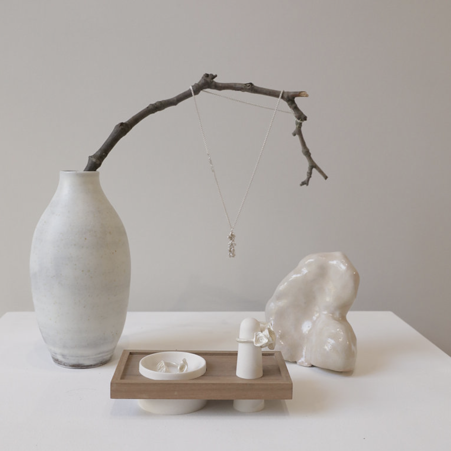 Minimalist event space at Arthill Gallery with a delicate necklace and elegant decor.