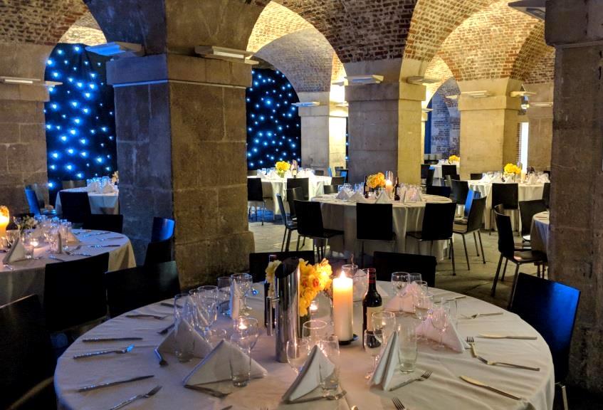 Elegant event space in St Martin-in-the-Fields with round tables and starry backdrop.