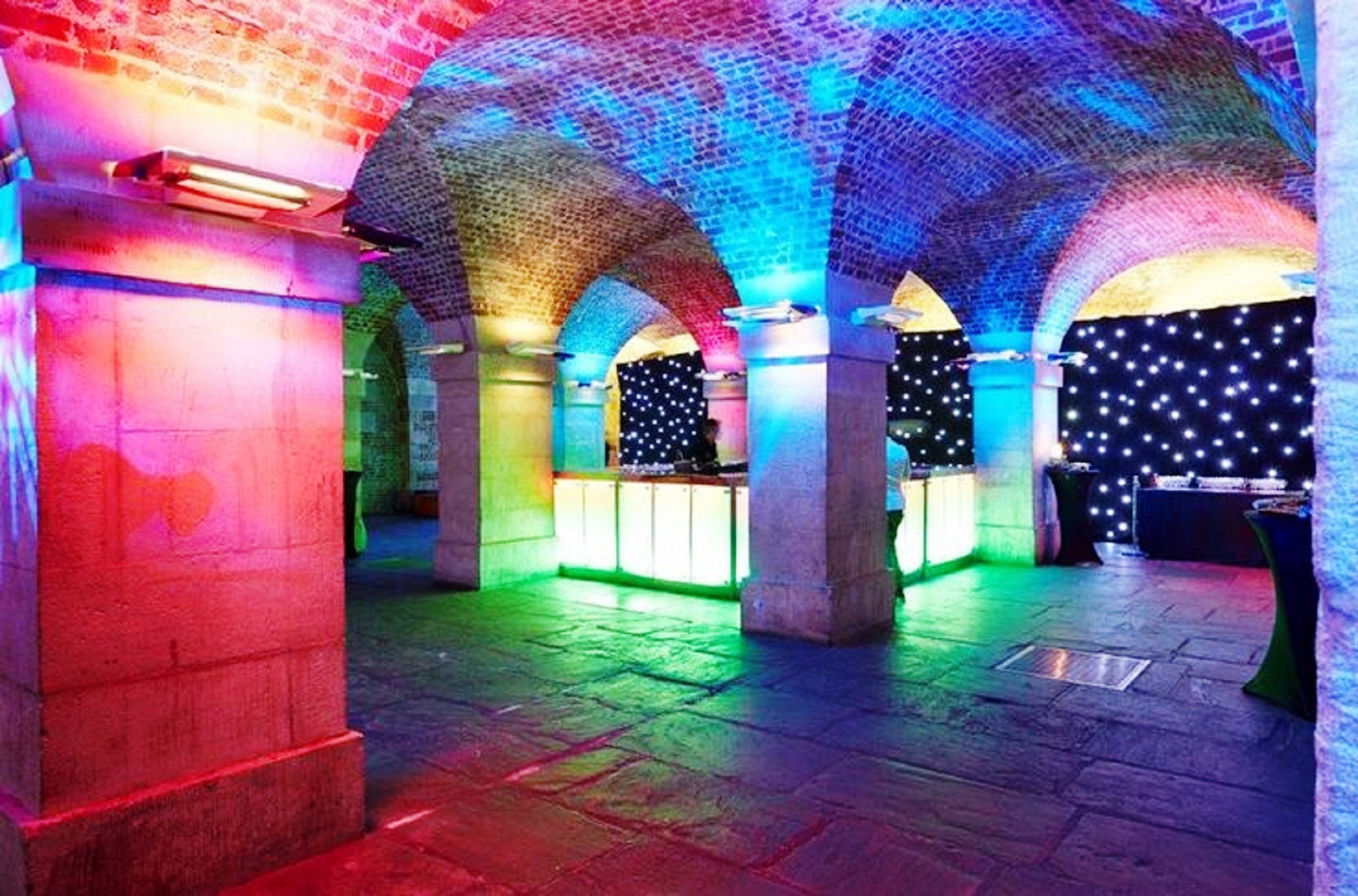 Vibrant event space in St Martin-in-the-Fields with colorful lighting for celebrations.