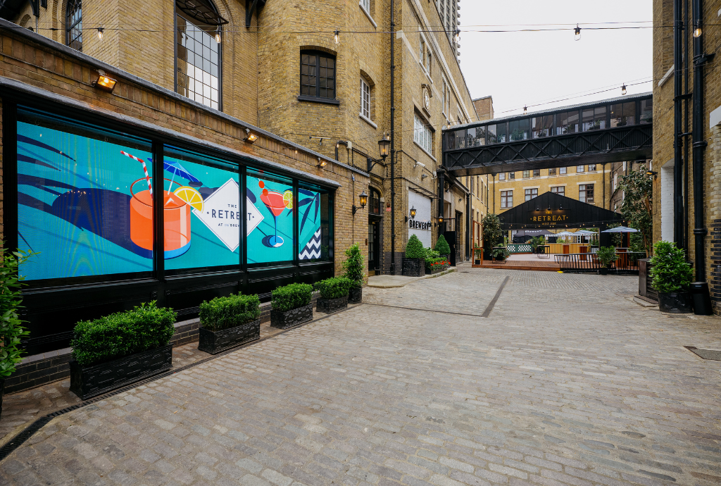 Vibrant outdoor summer party at The Retreat with colorful murals and stylish canopy.