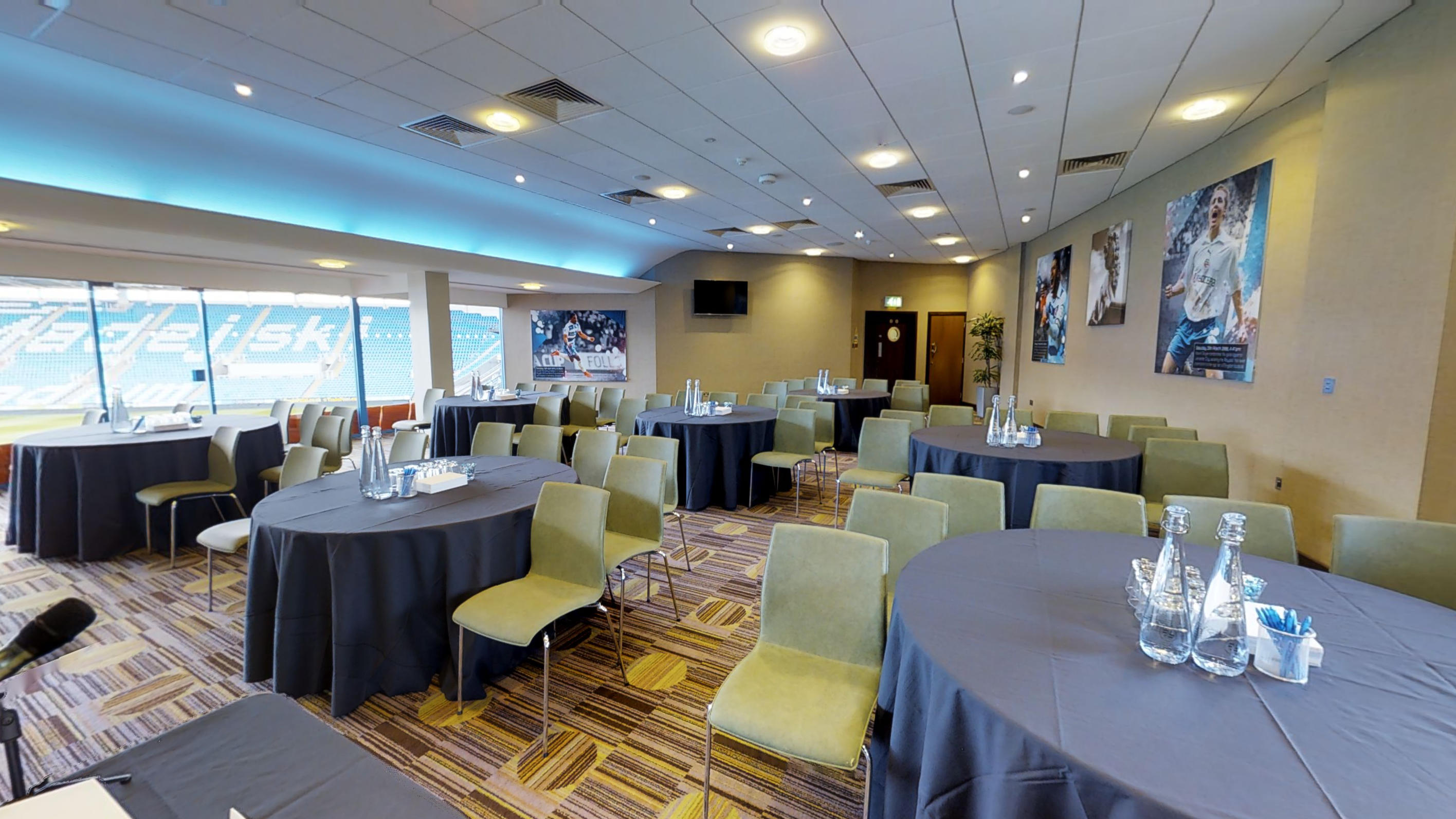 Premier Suite at Reading FC: elegant meeting space with round tables and large windows.