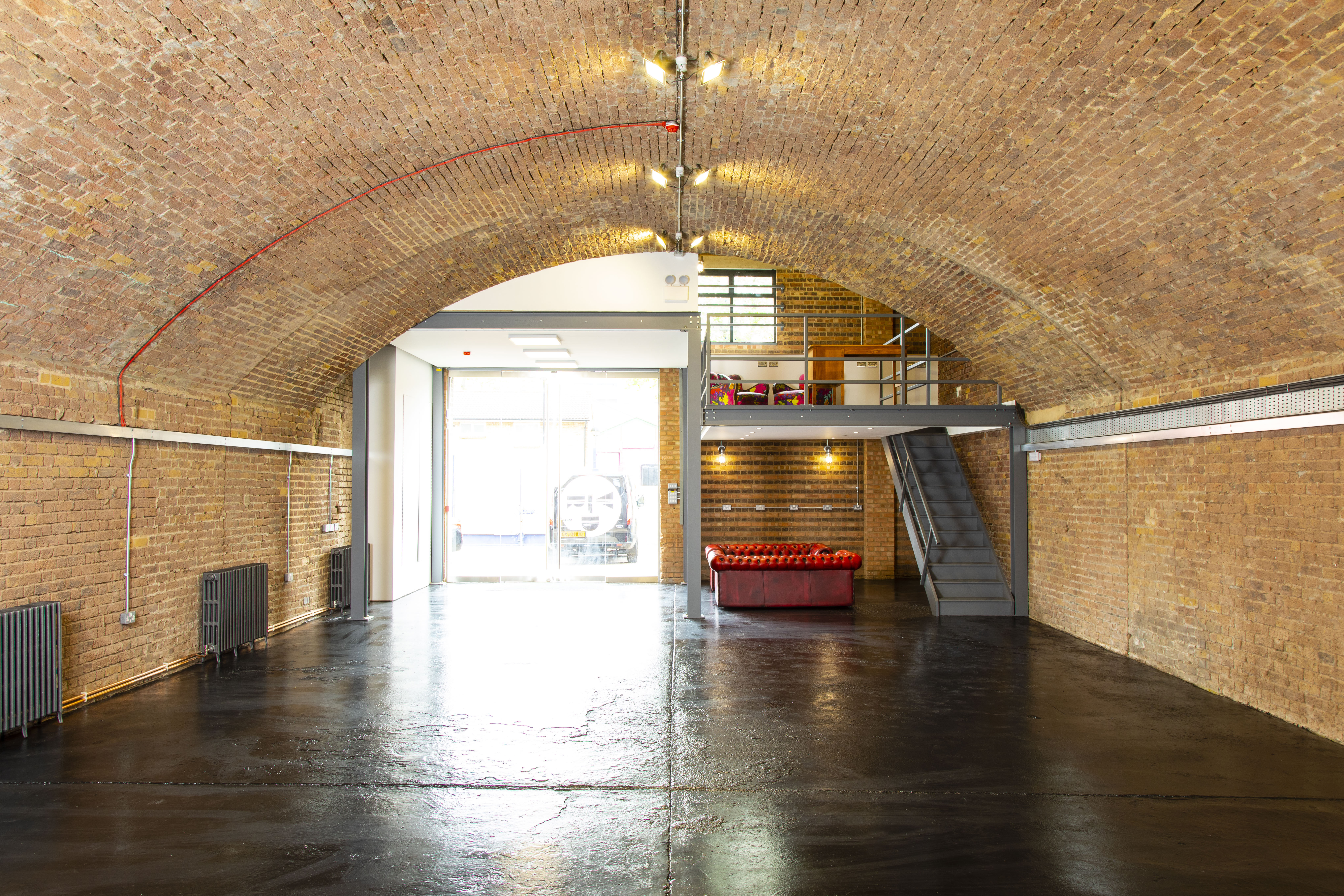 Versatile event space with exposed brick arches for corporate meetings and social gatherings.