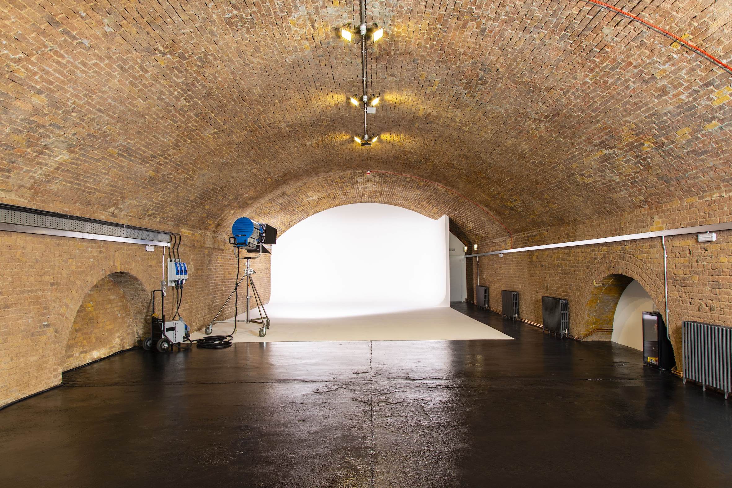 Versatile event space in Rida Haggerston with exposed brick and arched ceiling.