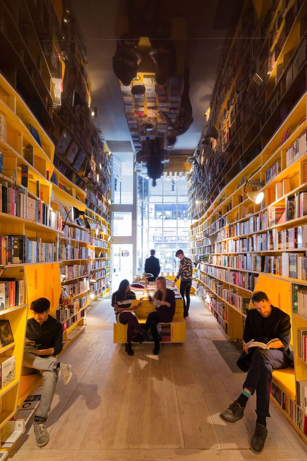 Vibrant bookshop with yellow shelves, ideal for creative meetings and workshops.
