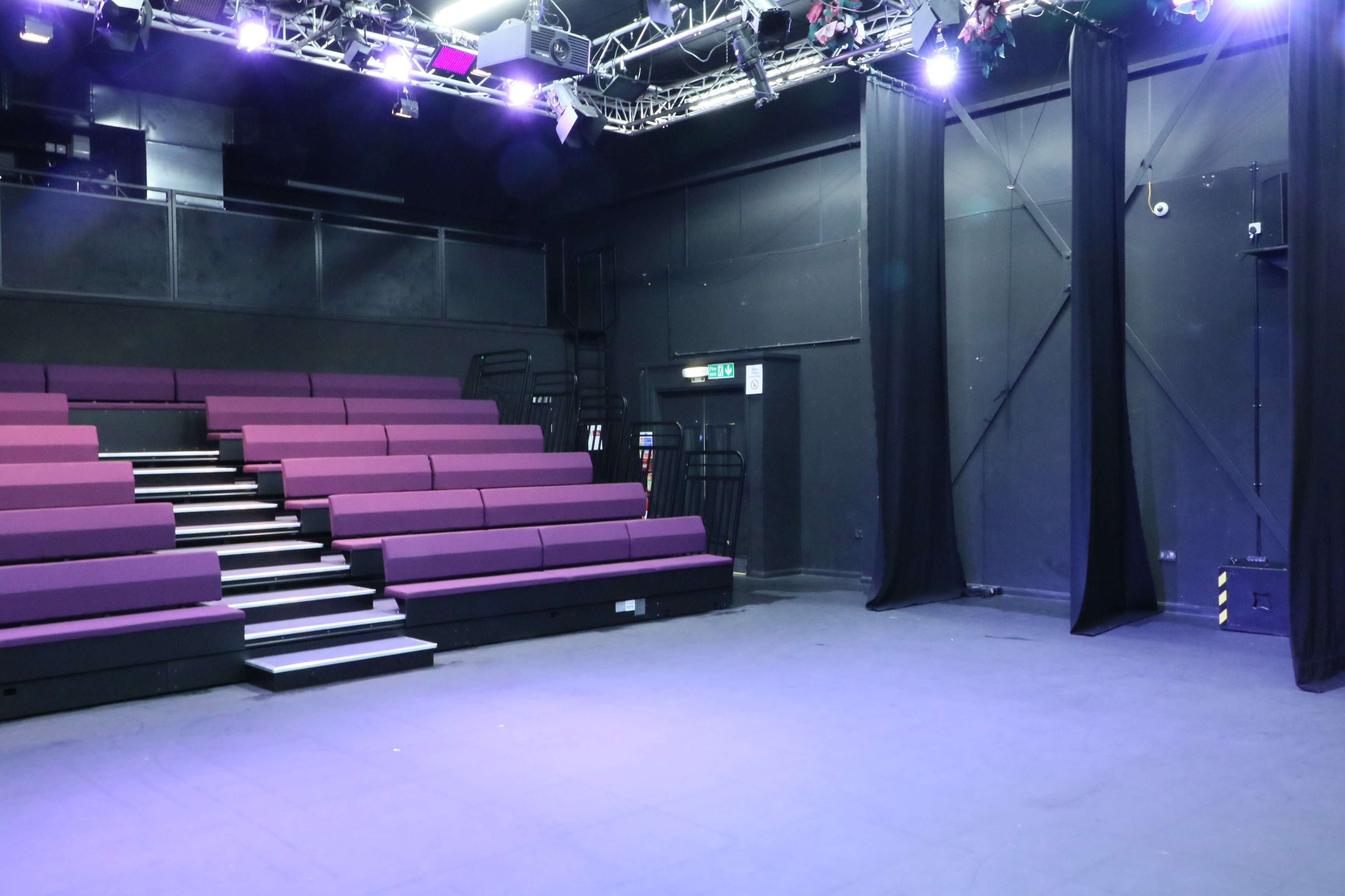 Theatre and conference space with tiered seating for versatile events at Impact Community Arts Centre.