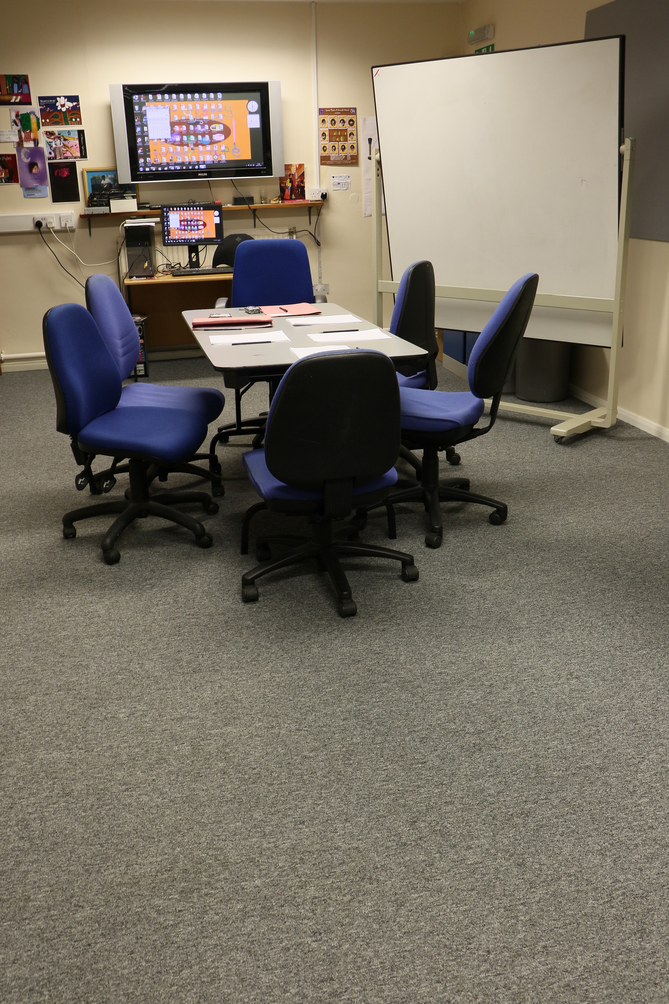 Small meeting room with blue ergonomic chairs, perfect for team discussions and brainstorming.