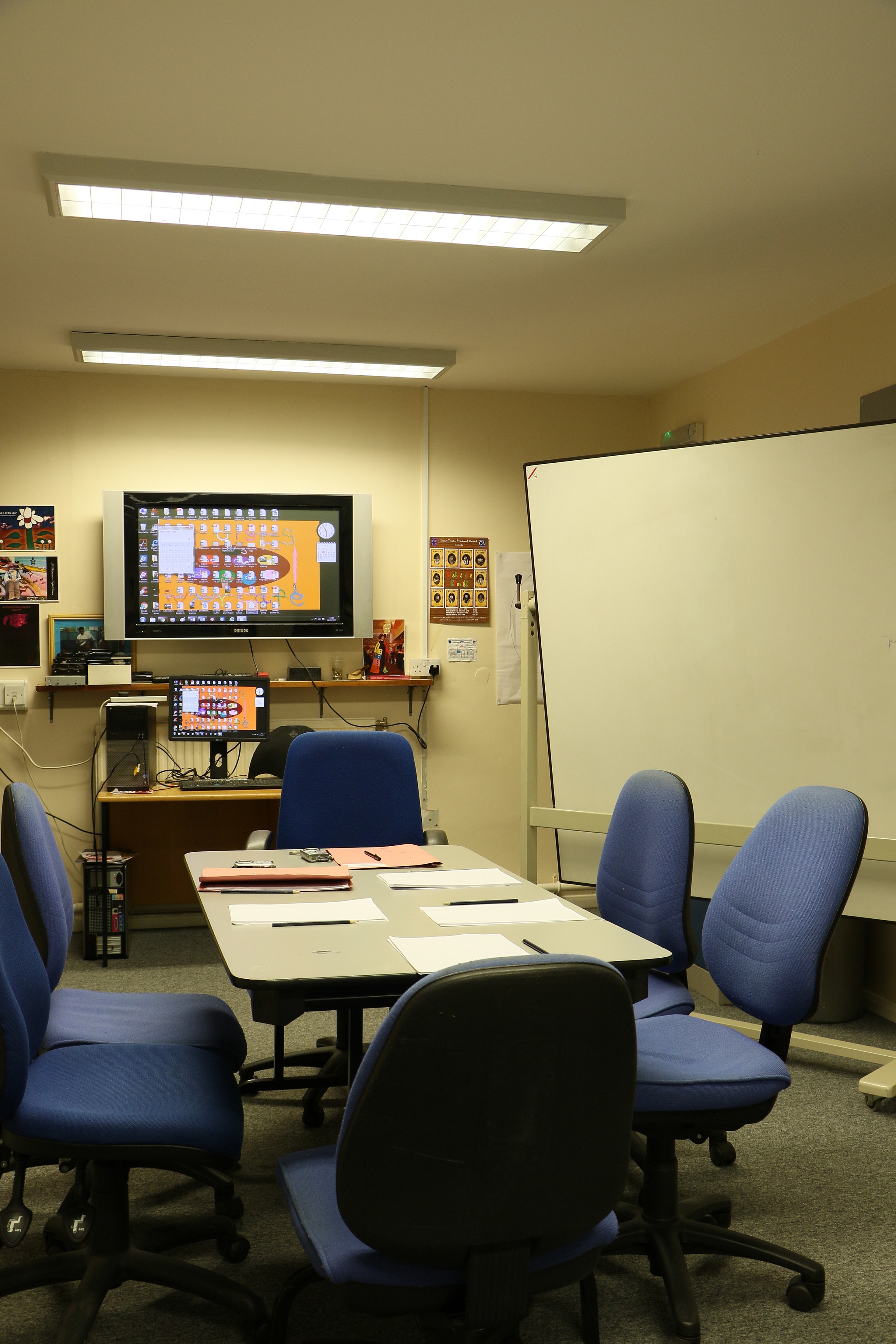 Meeting room with large screen, ideal for seminars and collaborative events.