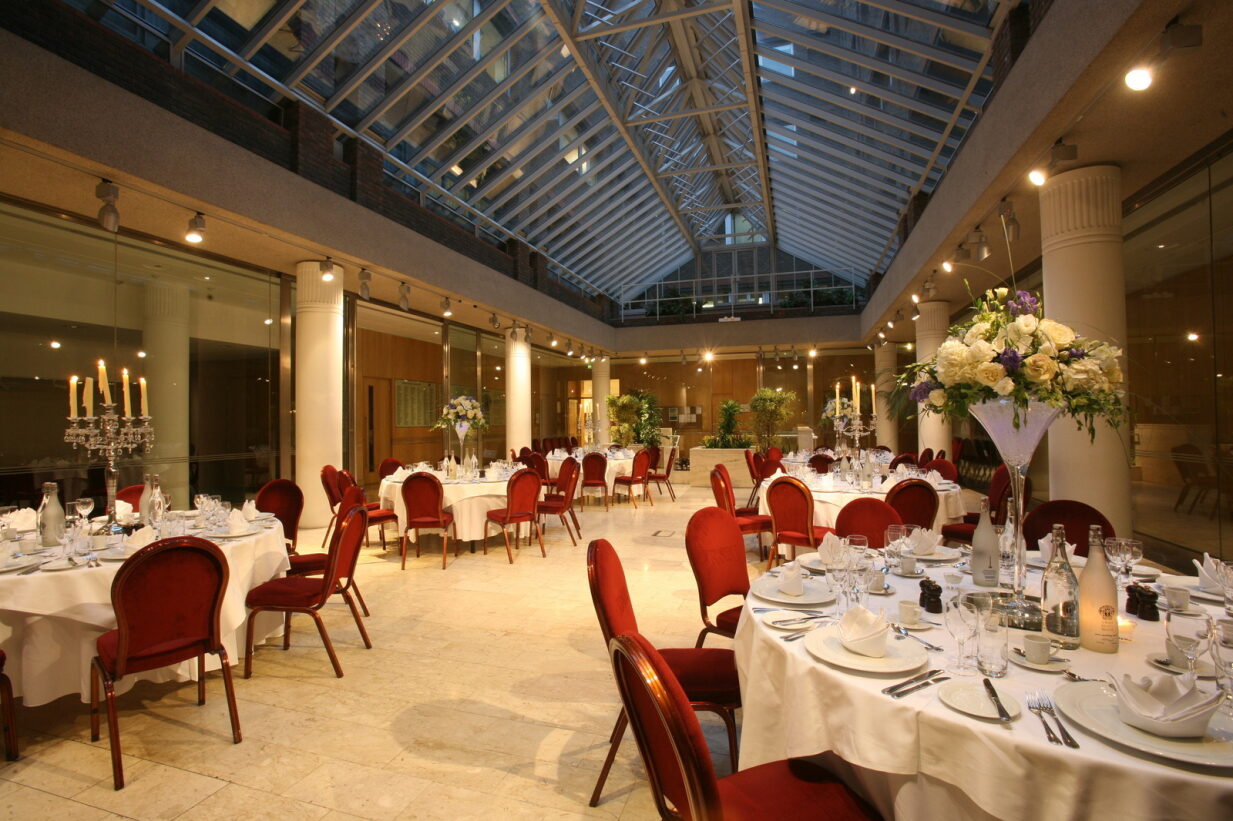 Max Rayne Atrium event space with elegant round tables, perfect for weddings and galas.