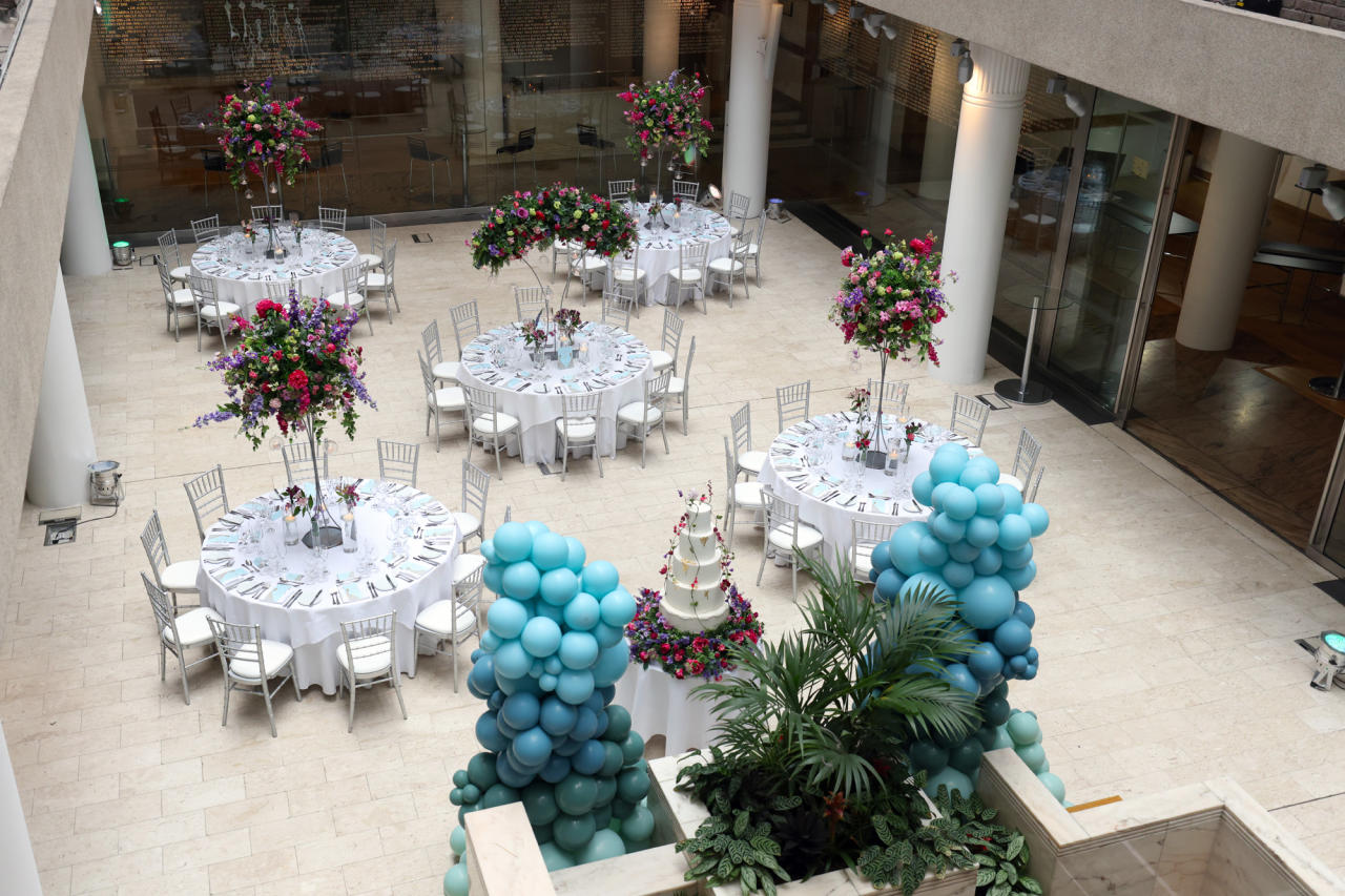 Max Rayne Atrium event space with elegant tables and blue balloon decor for celebrations.