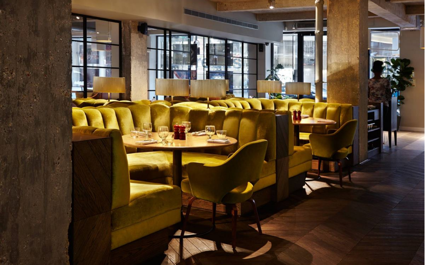 Modern restaurant with vibrant yellow seating, ideal for intimate events and gatherings.