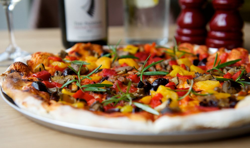 Vibrant gourmet pizza with fresh vegetables for catering at networking events.