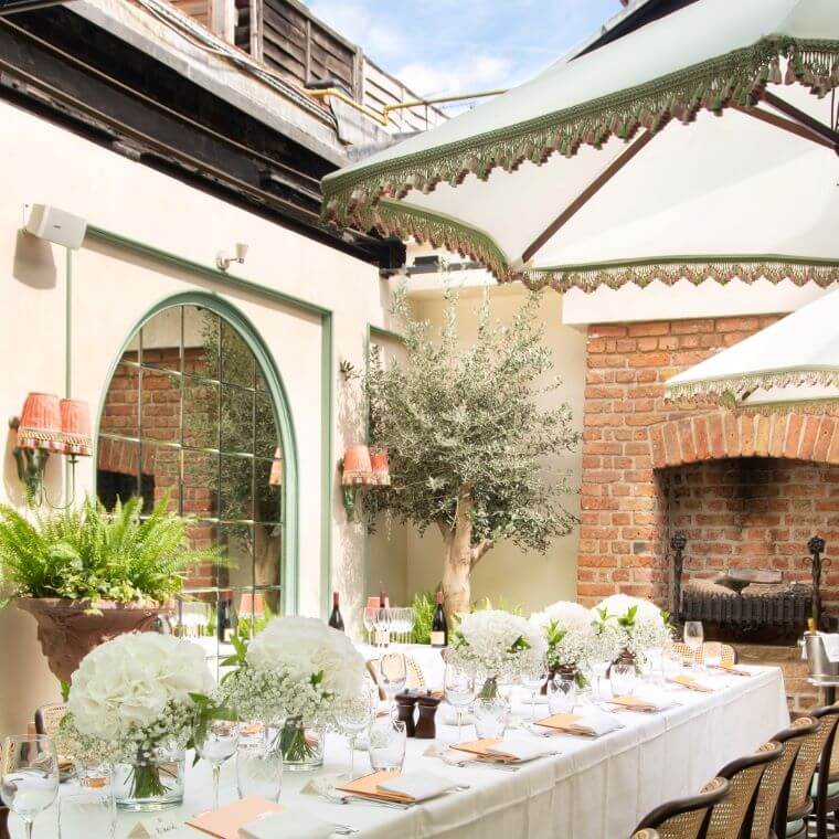 Elegant outdoor event space at The Conservatory with white floral centerpieces.