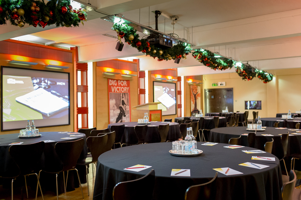 HCA Auditorium with round tables, ideal for corporate meetings and events.