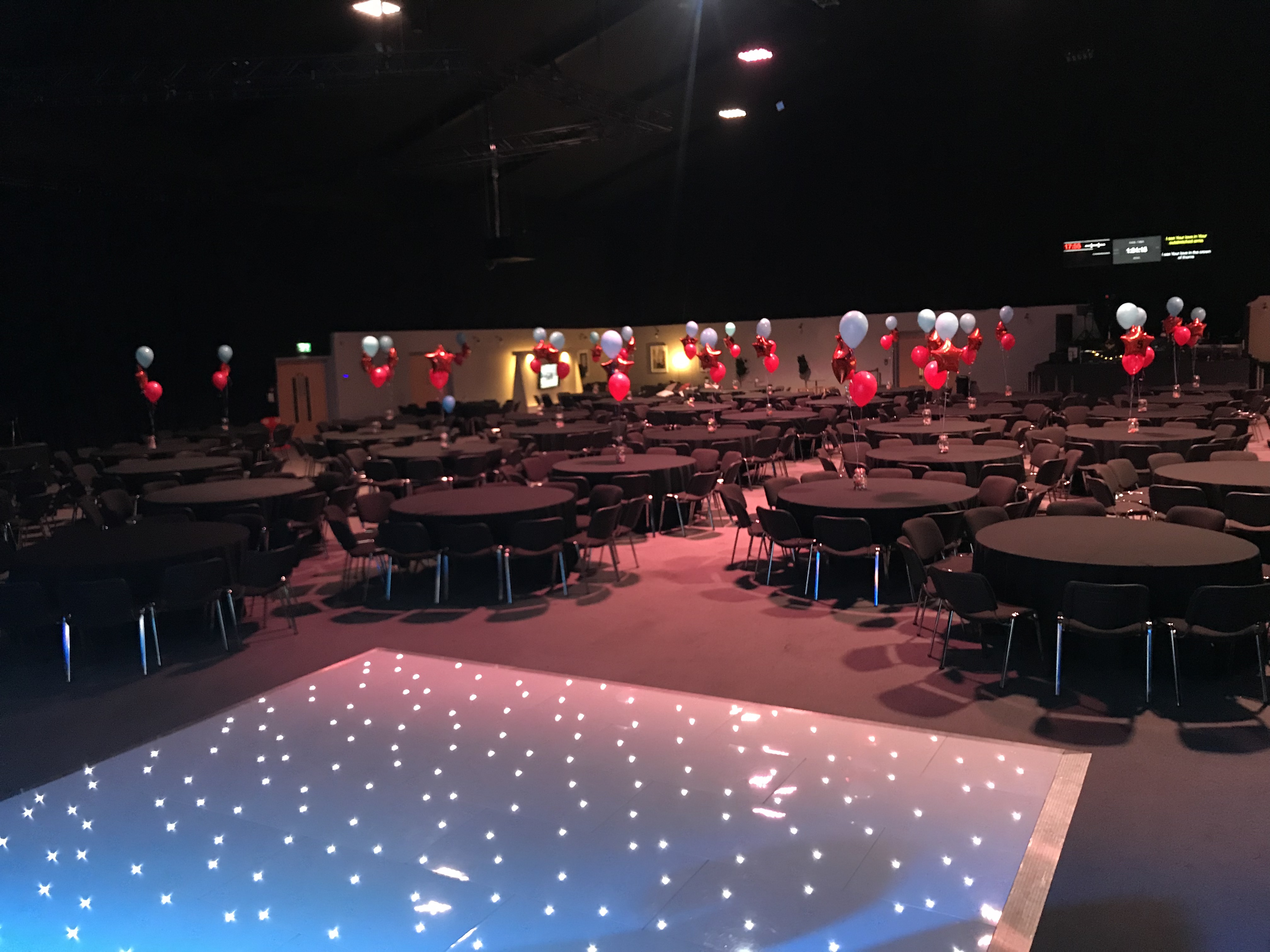 Elegant auditorium with round tables, balloons for corporate events and celebrations.