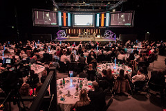 Auditorium at !Audacious Conferencing with large audience at round tables for successful event.