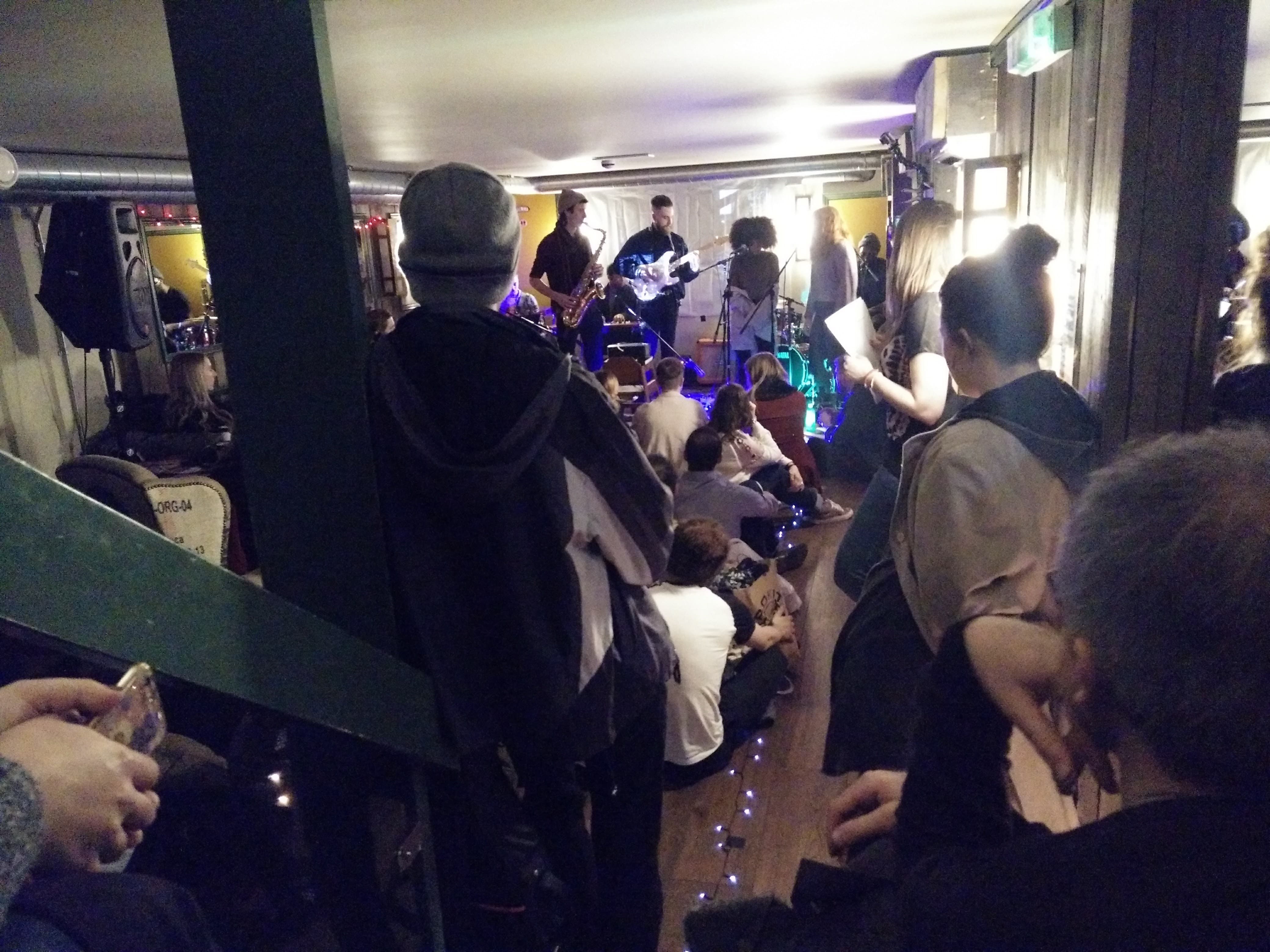 Vibrant live performance in cozy Cafe Zee basement, perfect for social gatherings and networking.