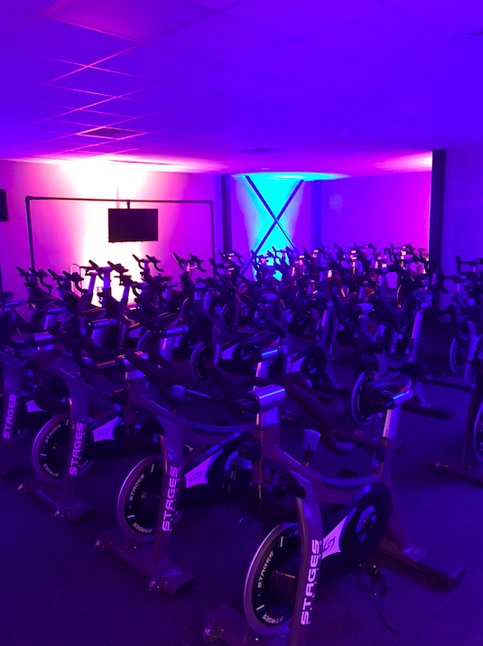 Vibrant indoor cycling studio with dynamic lighting for fitness events and wellness retreats.