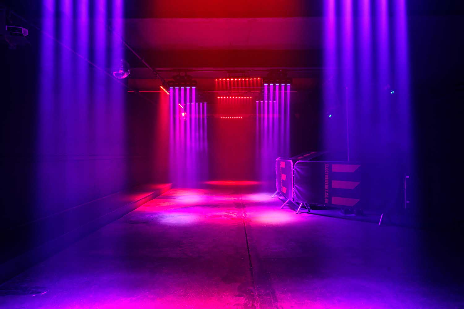 Industrial event venue with purple/red lights for launch or performance.