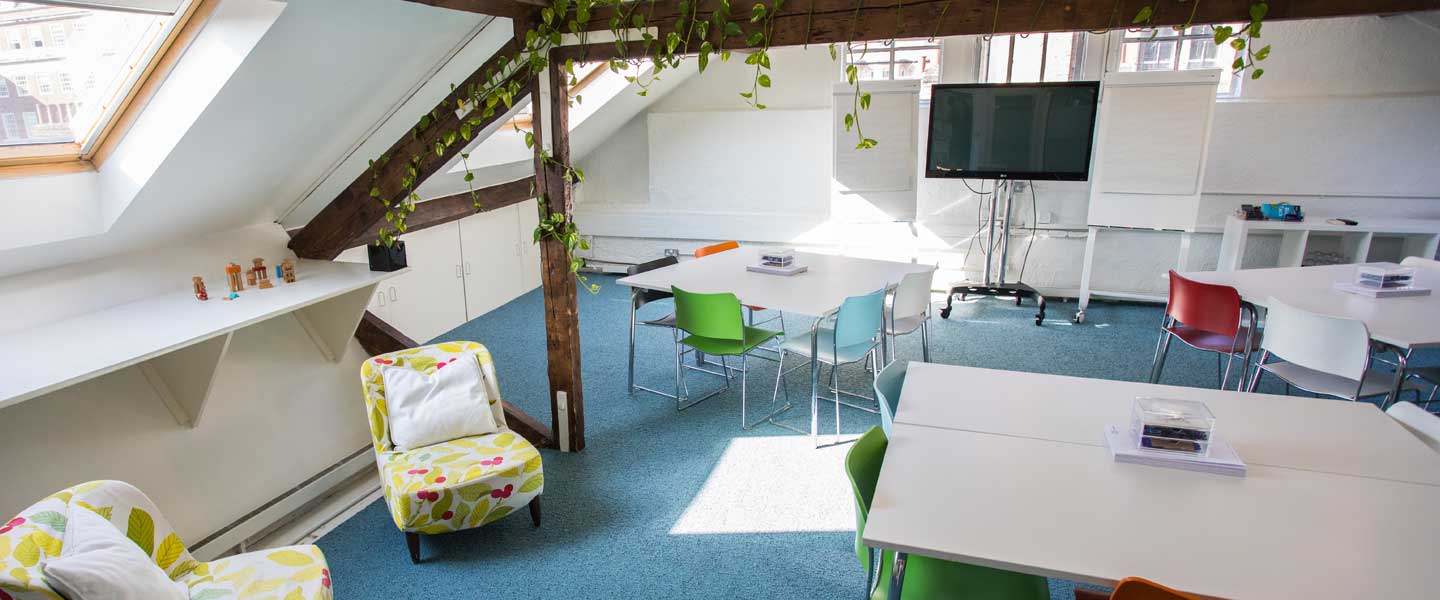 Bright modern meeting space with colorful chairs, perfect for workshops and brainstorming.