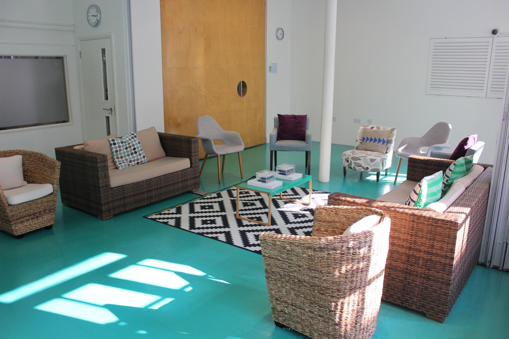 Collaborative meeting space with cozy seating and vibrant turquoise floor at Wallacespace.