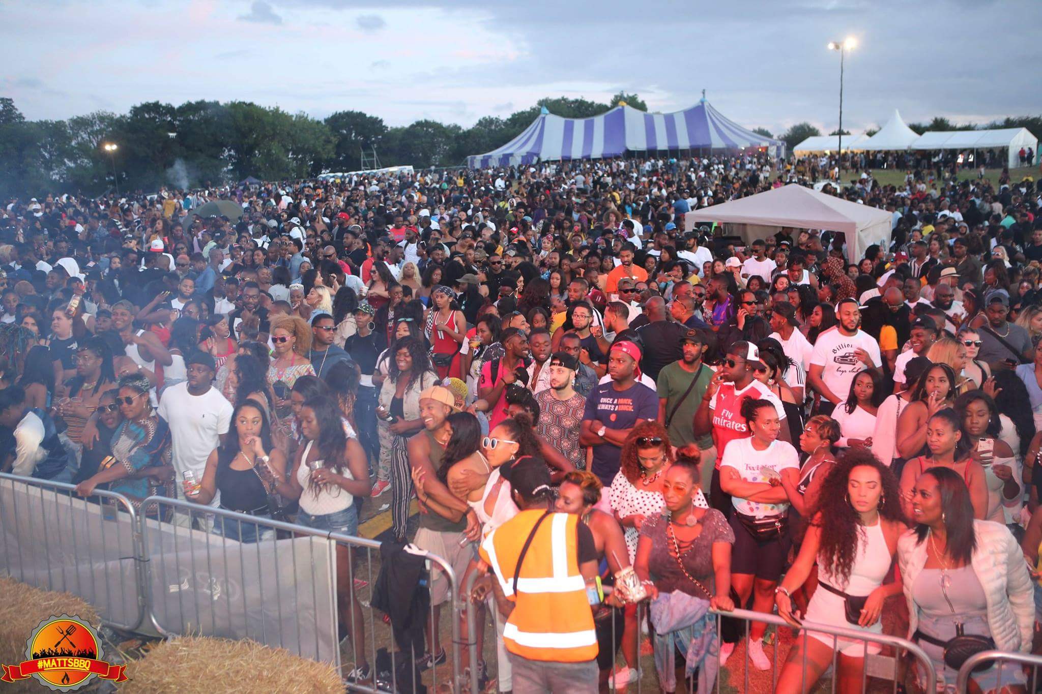 Vibrant outdoor event at Colesdale Farm with large crowd and tents for activities.