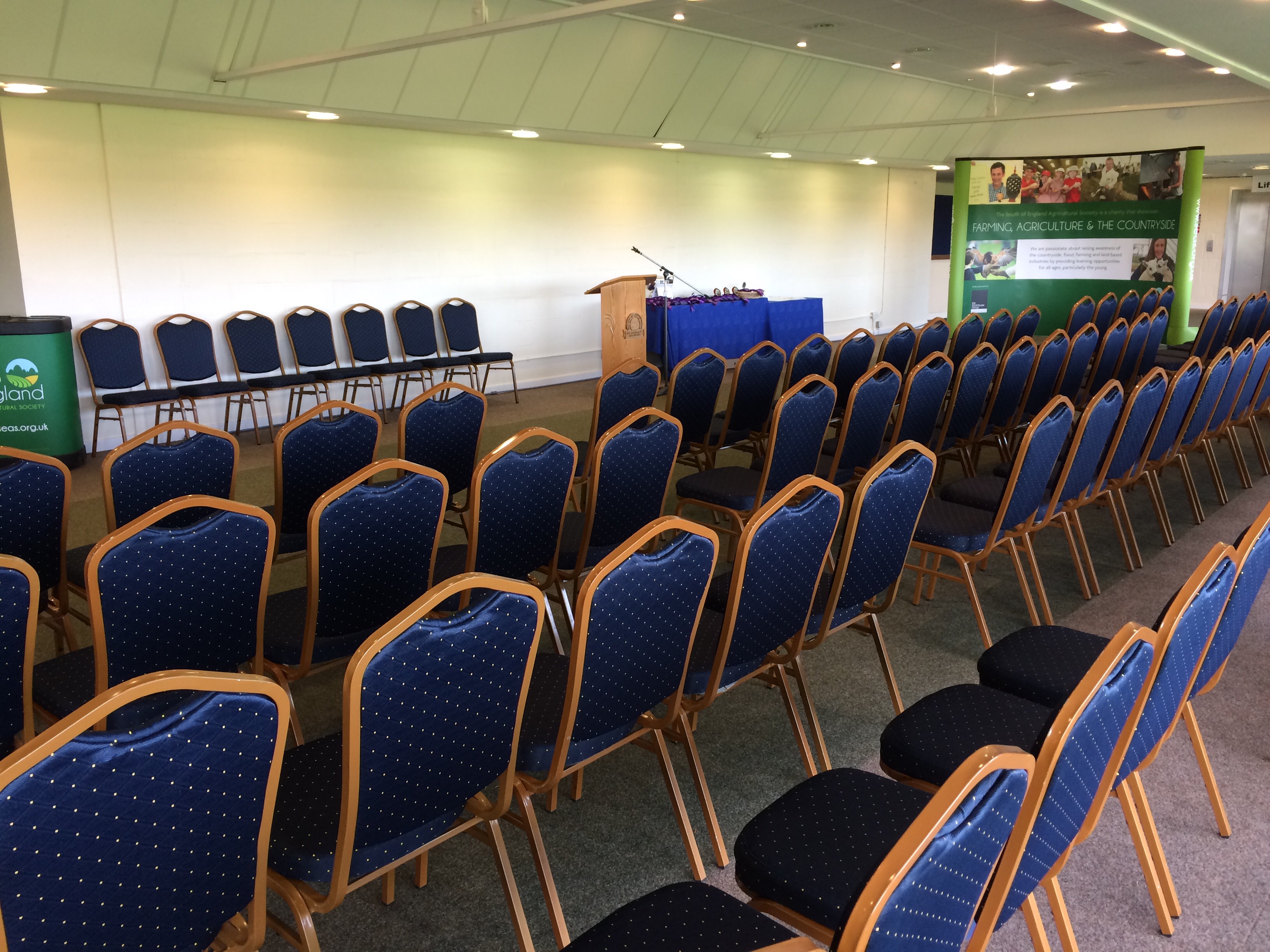 Balcombe Room setup with blue chairs for a professional presentation event.