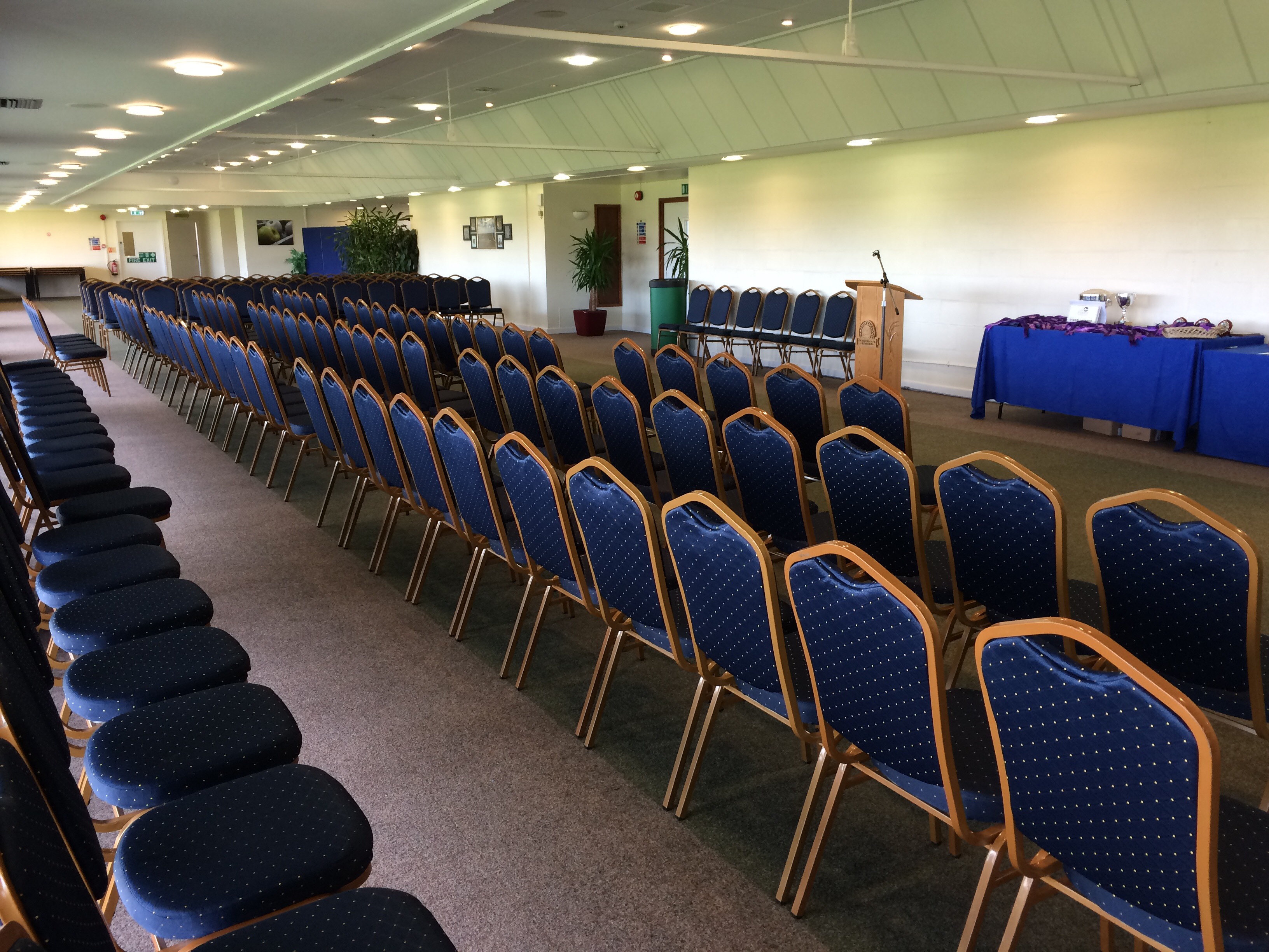 Balcombe Room setup for a meeting with blue chairs and podium in South England.