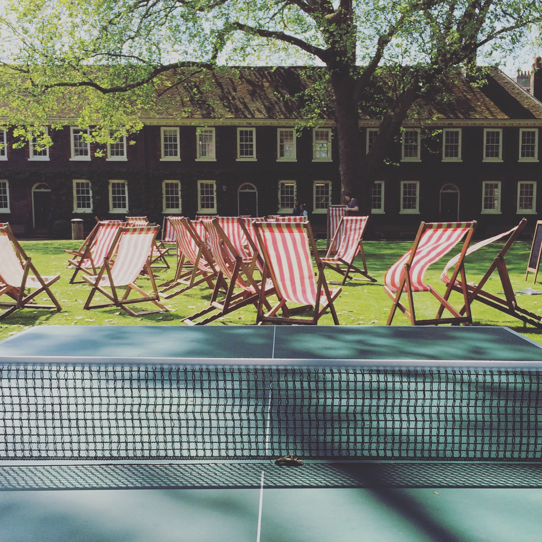 Vibrant outdoor event space with striped deck chairs for summer gatherings and team-building.