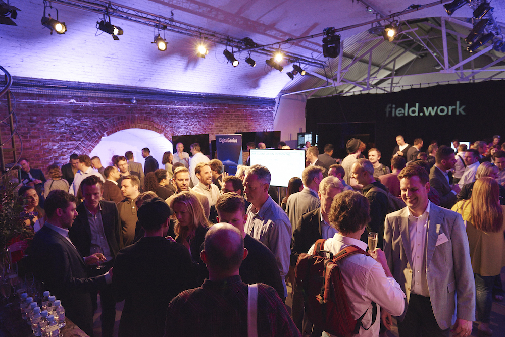 Vibrant networking event in Shoreditch Studios with engaged attendees and ambient lighting.