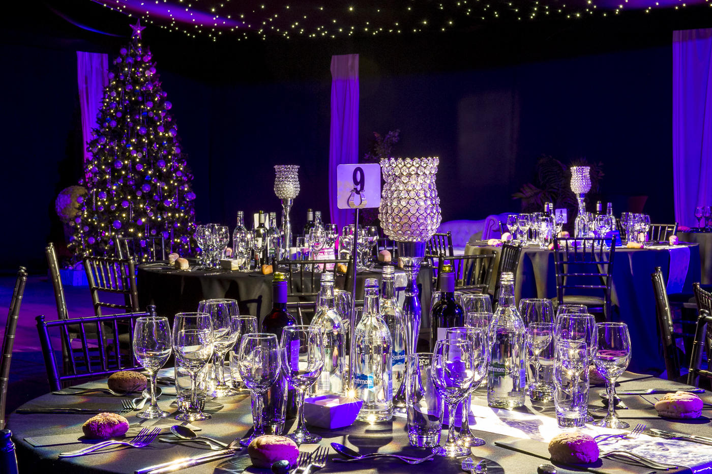 Elegant event space with round tables, perfect for upscale gatherings and holiday celebrations.