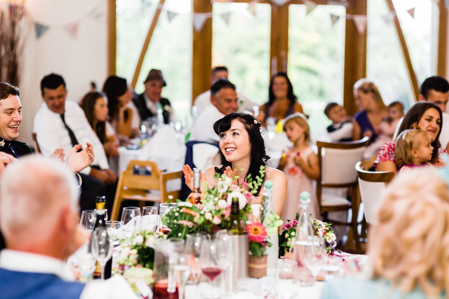 Wedding reception at Mythe Barn with elegant floral centerpieces and festive bunting.