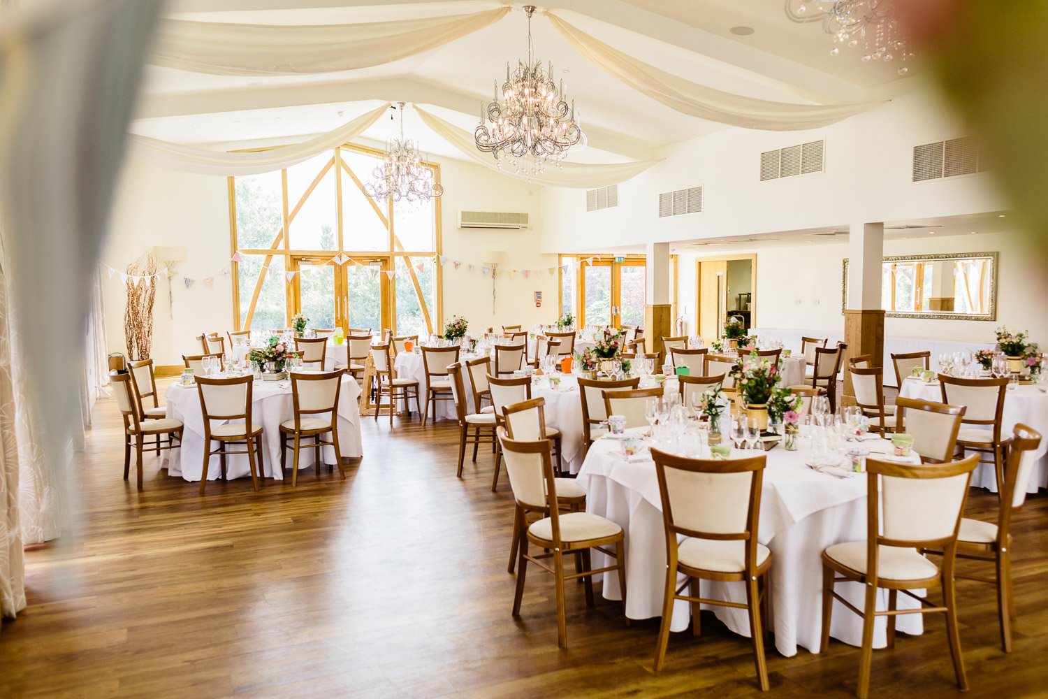 Elegant event space in Mythe Barn with round tables, ideal for weddings and corporate gatherings.